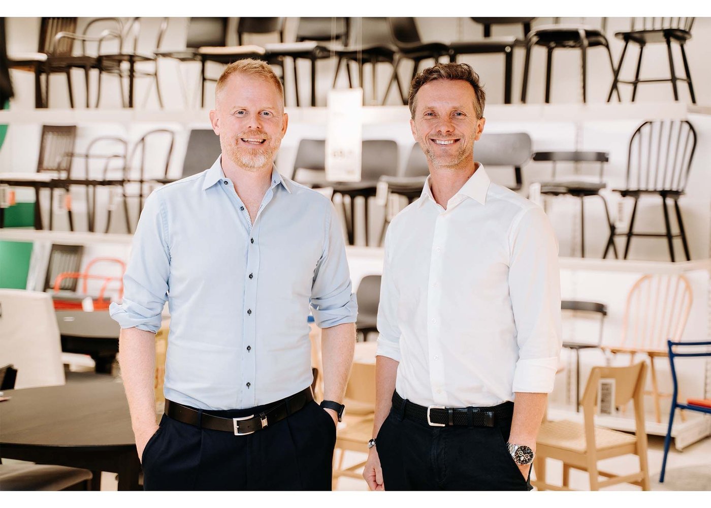 Jon Abrahamsson Ring and Kuba Jankowski stand in front of a wall of many chairs, displayed in rows. They smile at the camera.