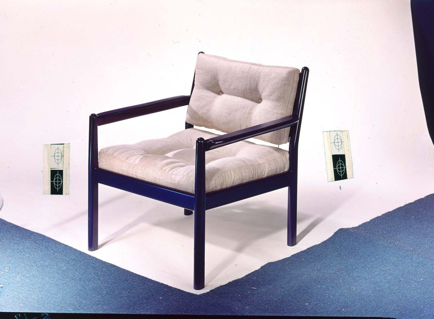 LONDON chair, placed on a white backdrop, with a blue floor.
