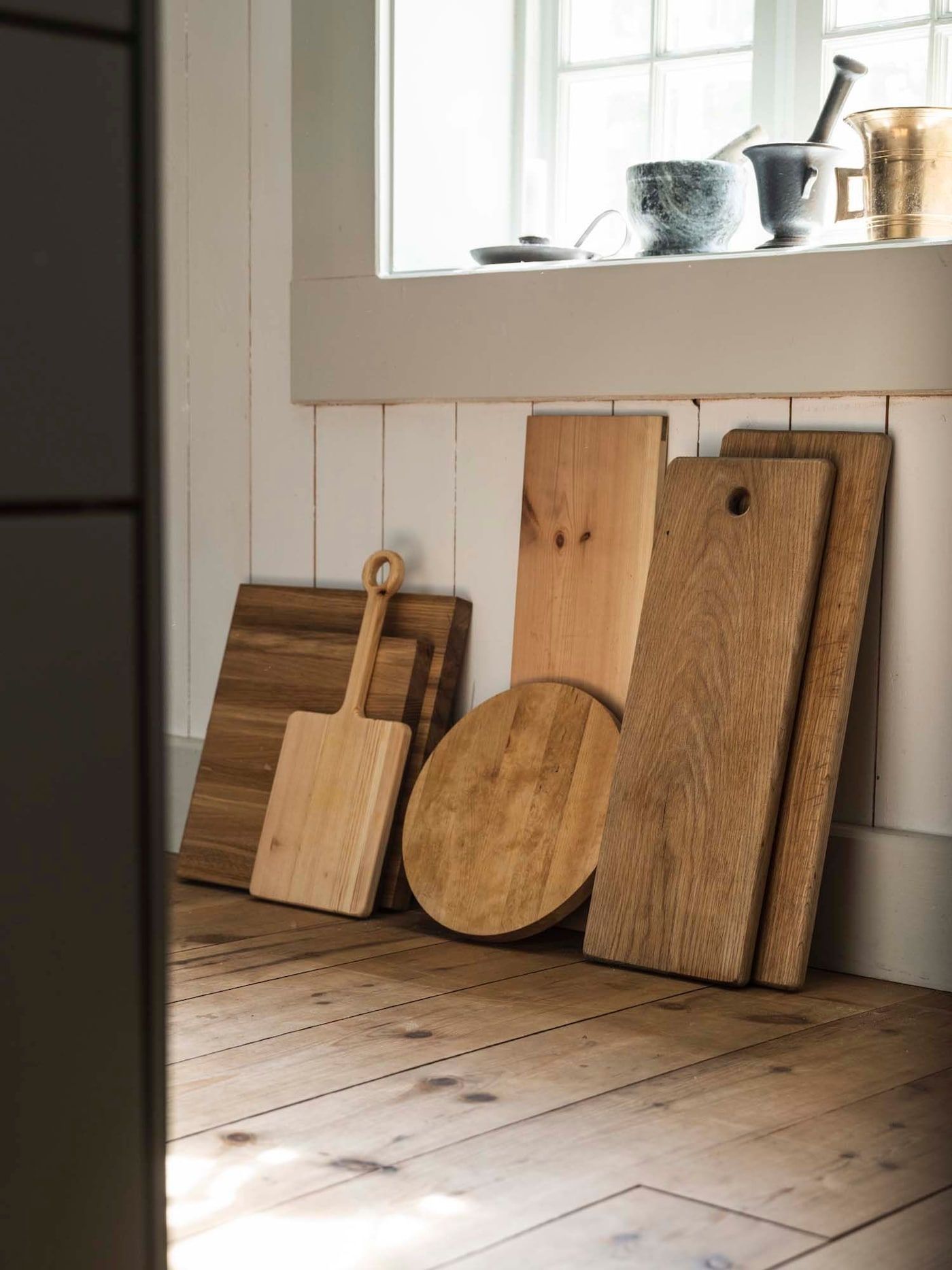 A collection of wooden cutting boards resting against the wall.