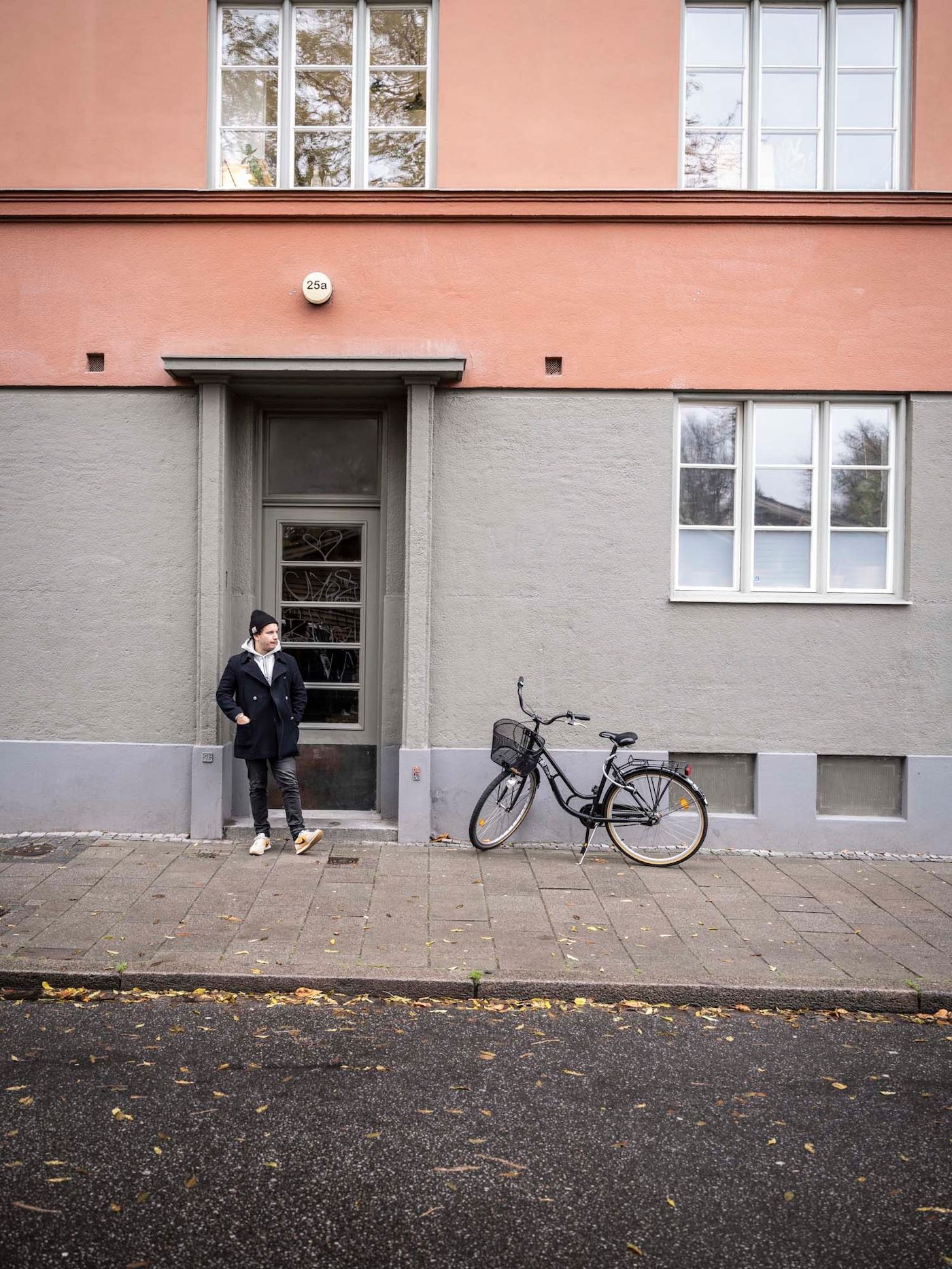 Linus and a bicycle on the street outside an apartment building.