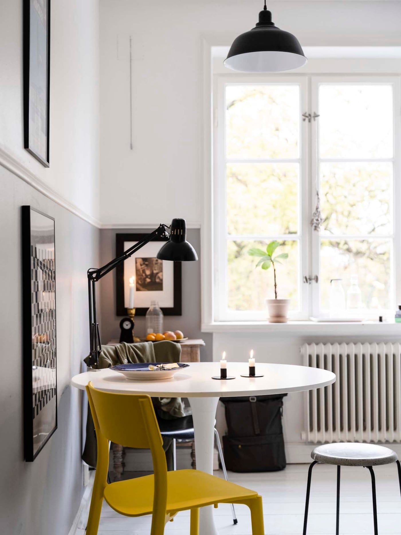A small dining area with a white, round table and mix of chairs.