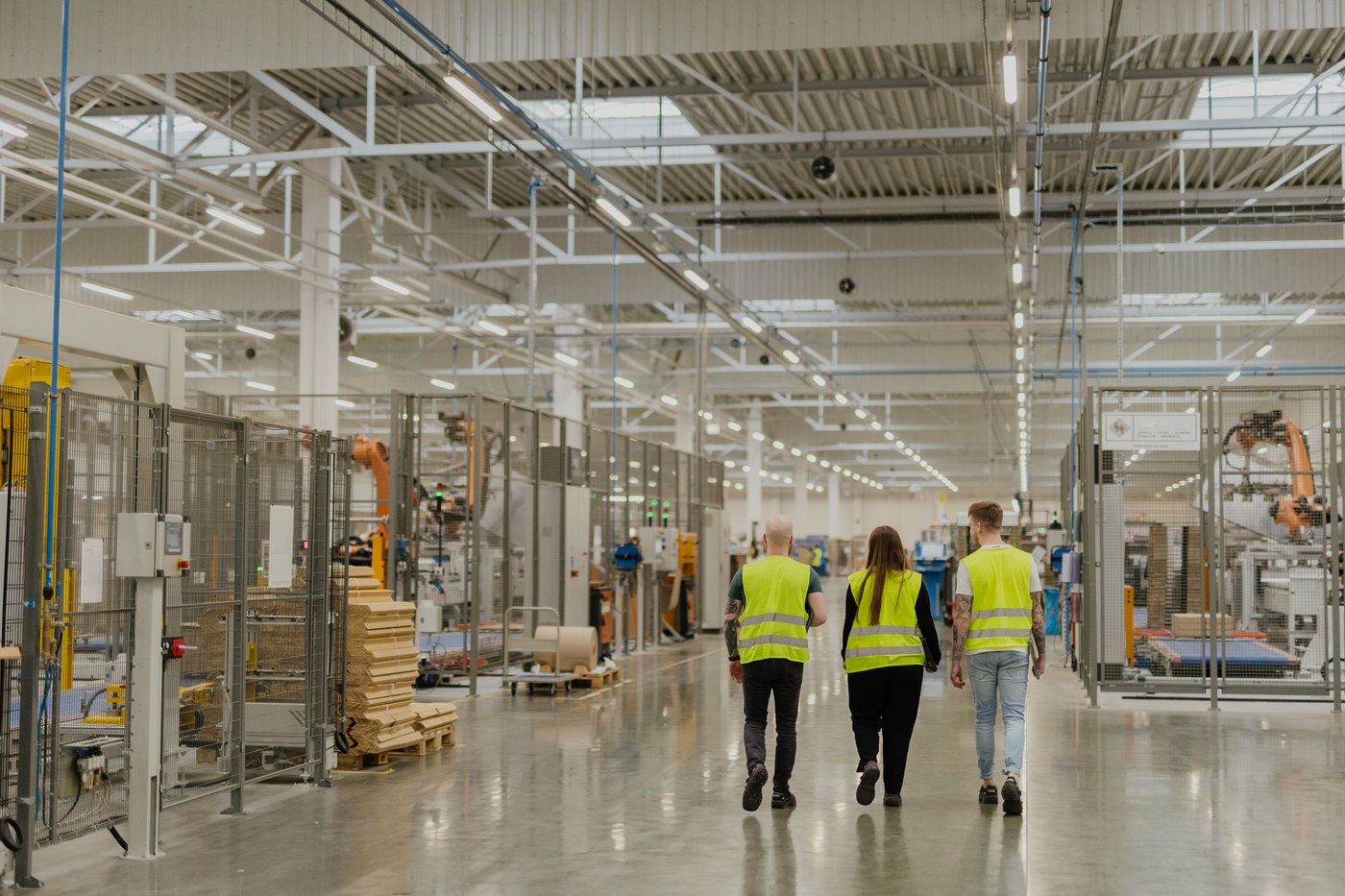 Three co-workers walk through a factory in Zbaszynek.