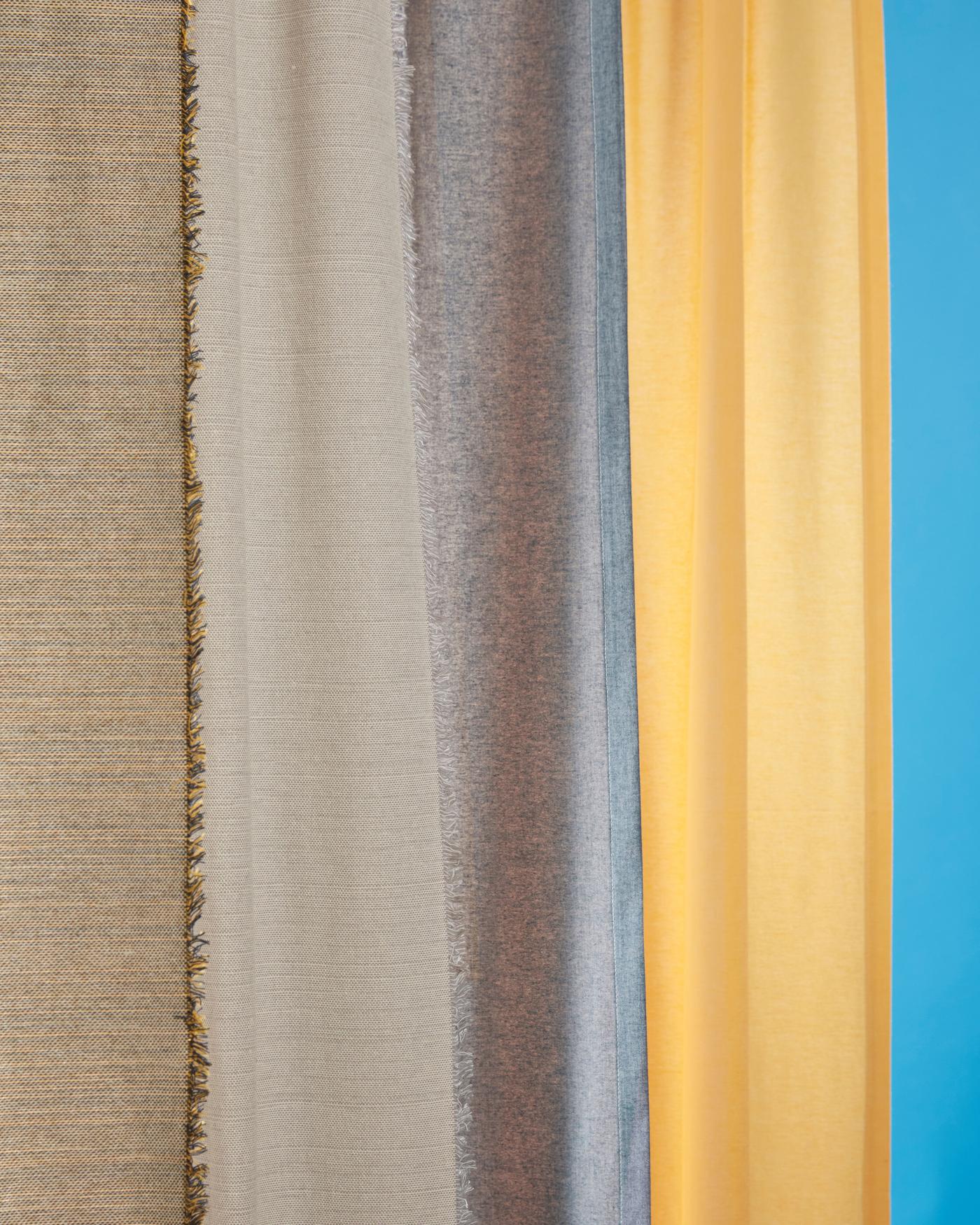 Curtains from the VÄXELBRUK collection in different earth tone to yellow shades.