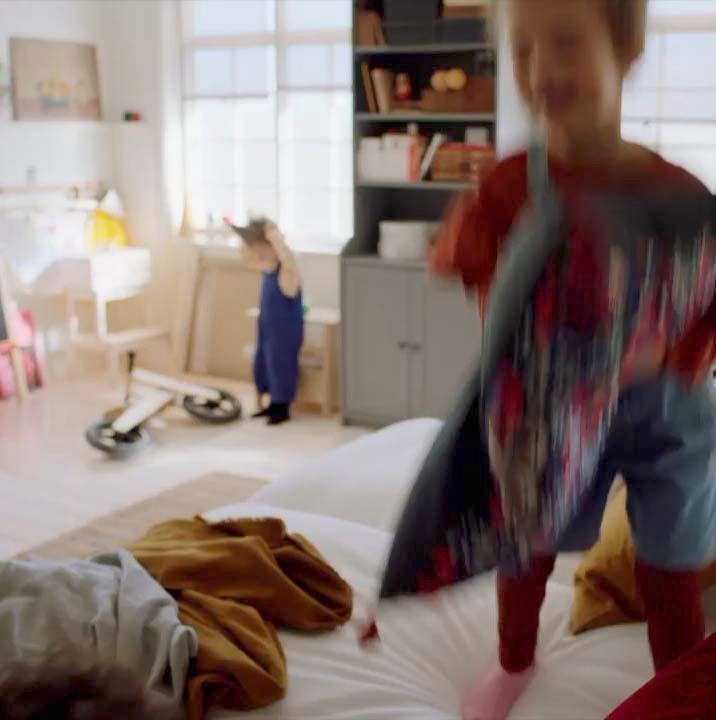 A still of a video, showing a melted ice cream lolly on a spotted wipe-clean tablecloth.