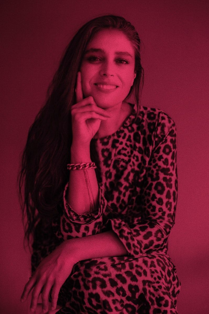 A dark pink colour-washed portrait of Trini Guzmán.