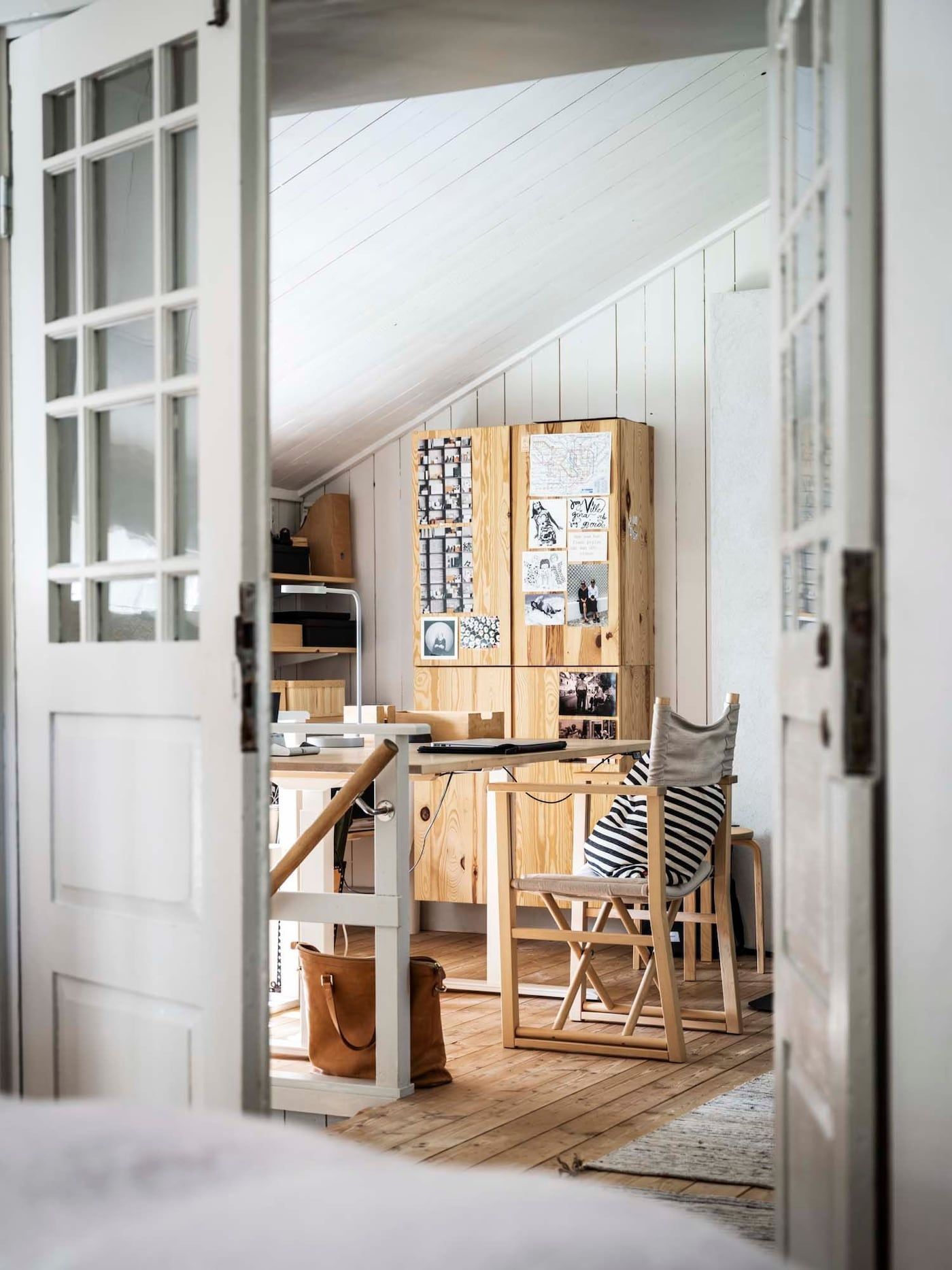 View through doors from a bedroom into a workspace area.