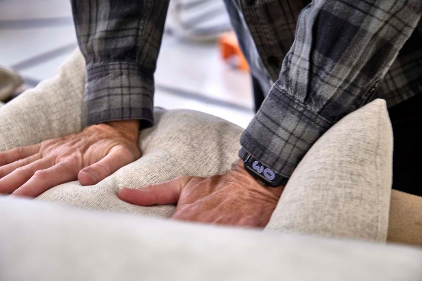 A close up of Ola Wihlborg checking the feel of the cushions on the SÖDERHAMN series.
