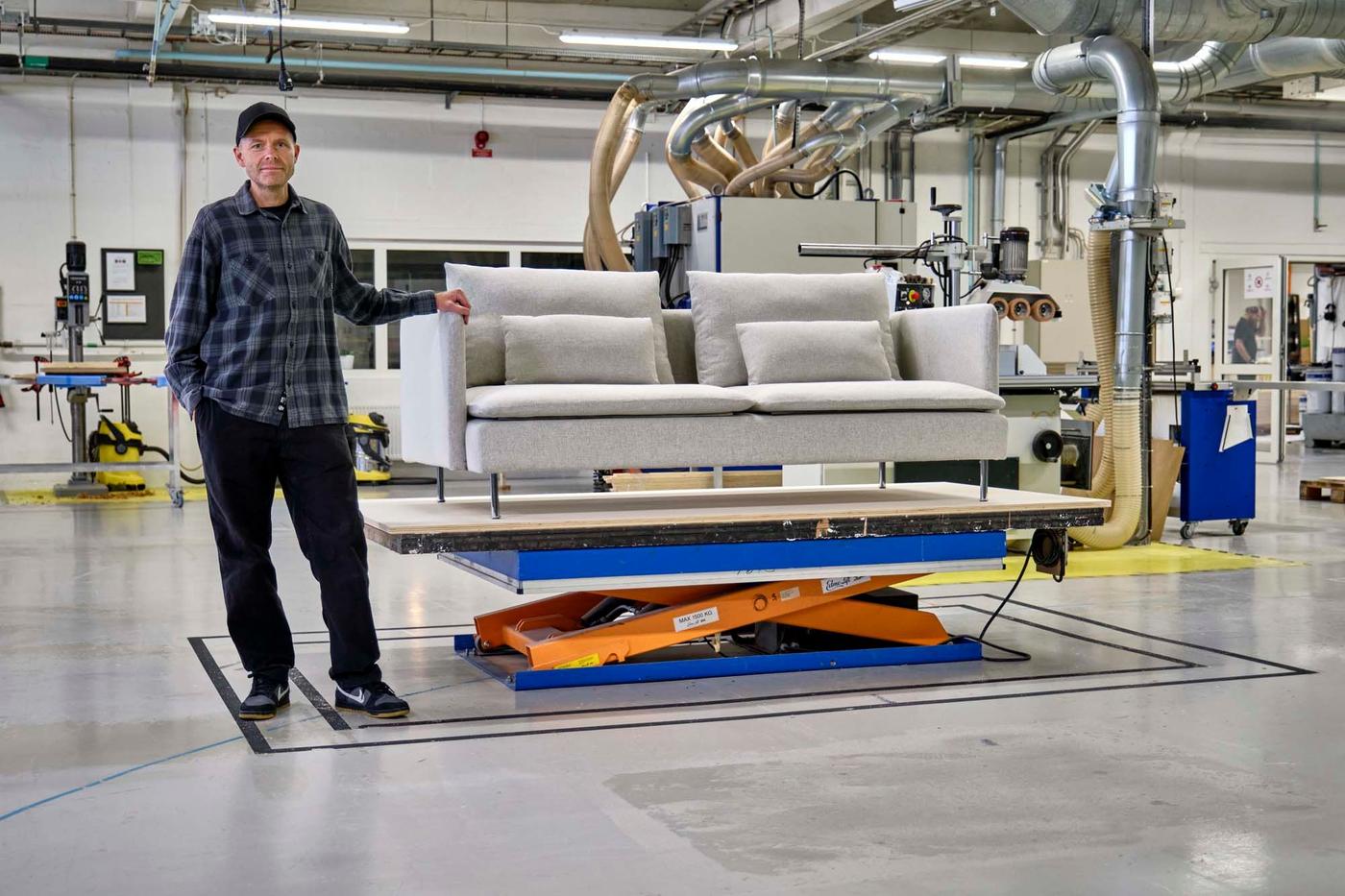 Designer Ola Wihlborg stands beside a grey SÖDERHAMN sofa.