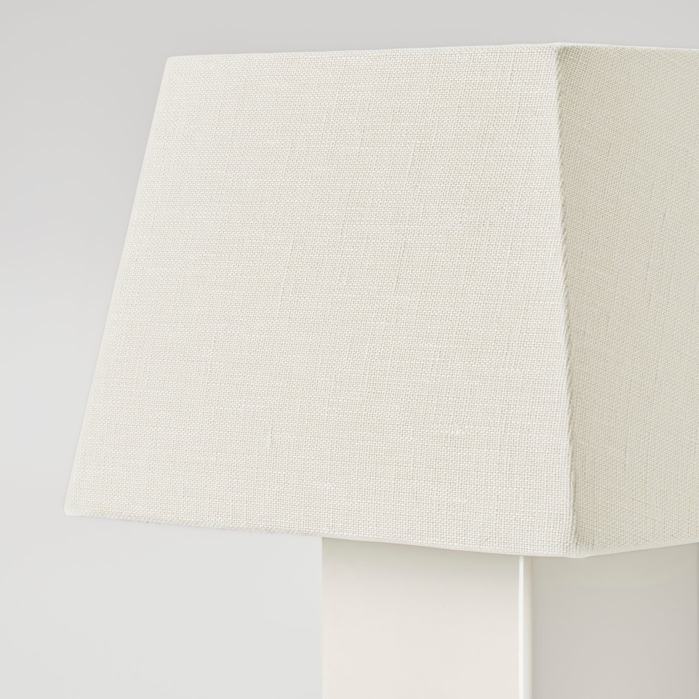 Close-up of a square lampshade in off-white linen with a soft, tactile texture.