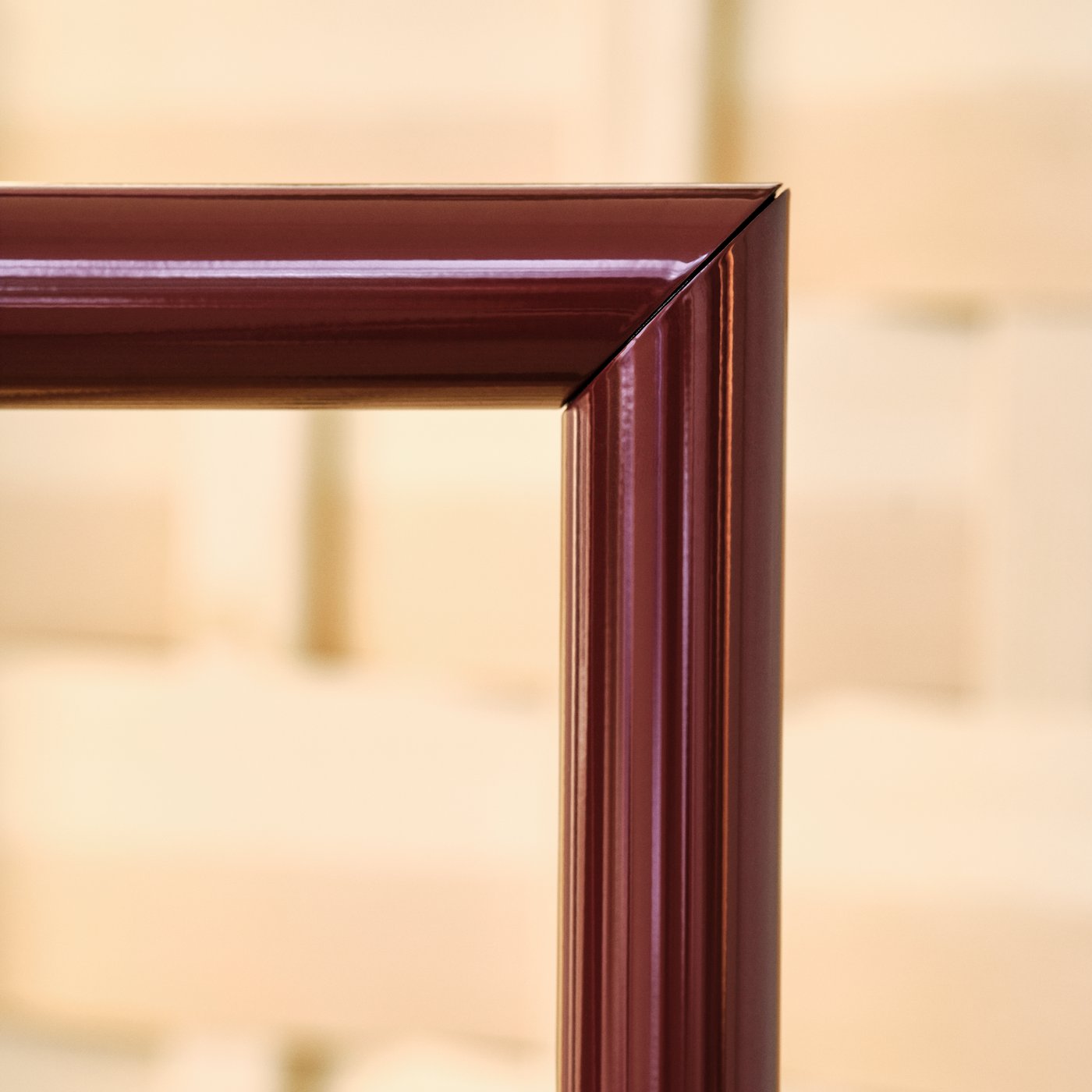 Close-up of a burgundy metal lamp frame showing a sharp right-angle joint.