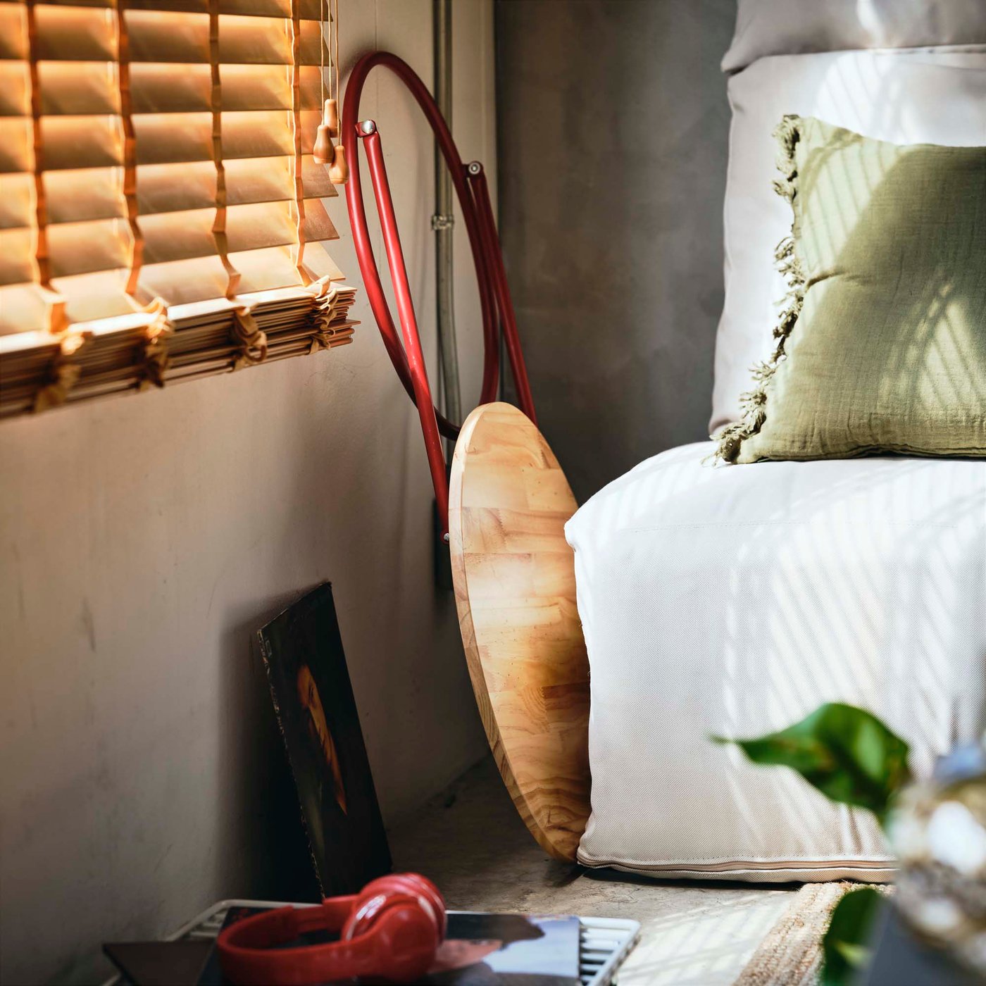 A wooden table with red metal legs folded away beside a sofa.