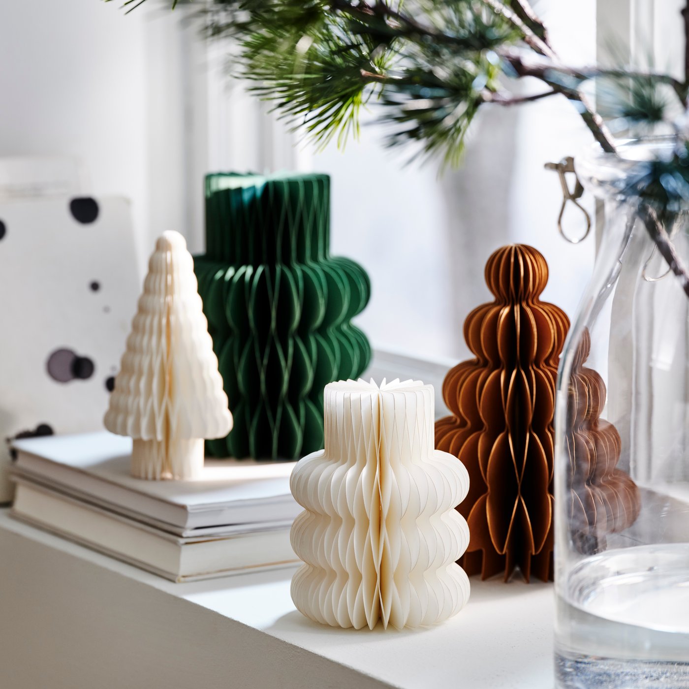 Paper decorations in different shapes and colours displayed on a windowsill.