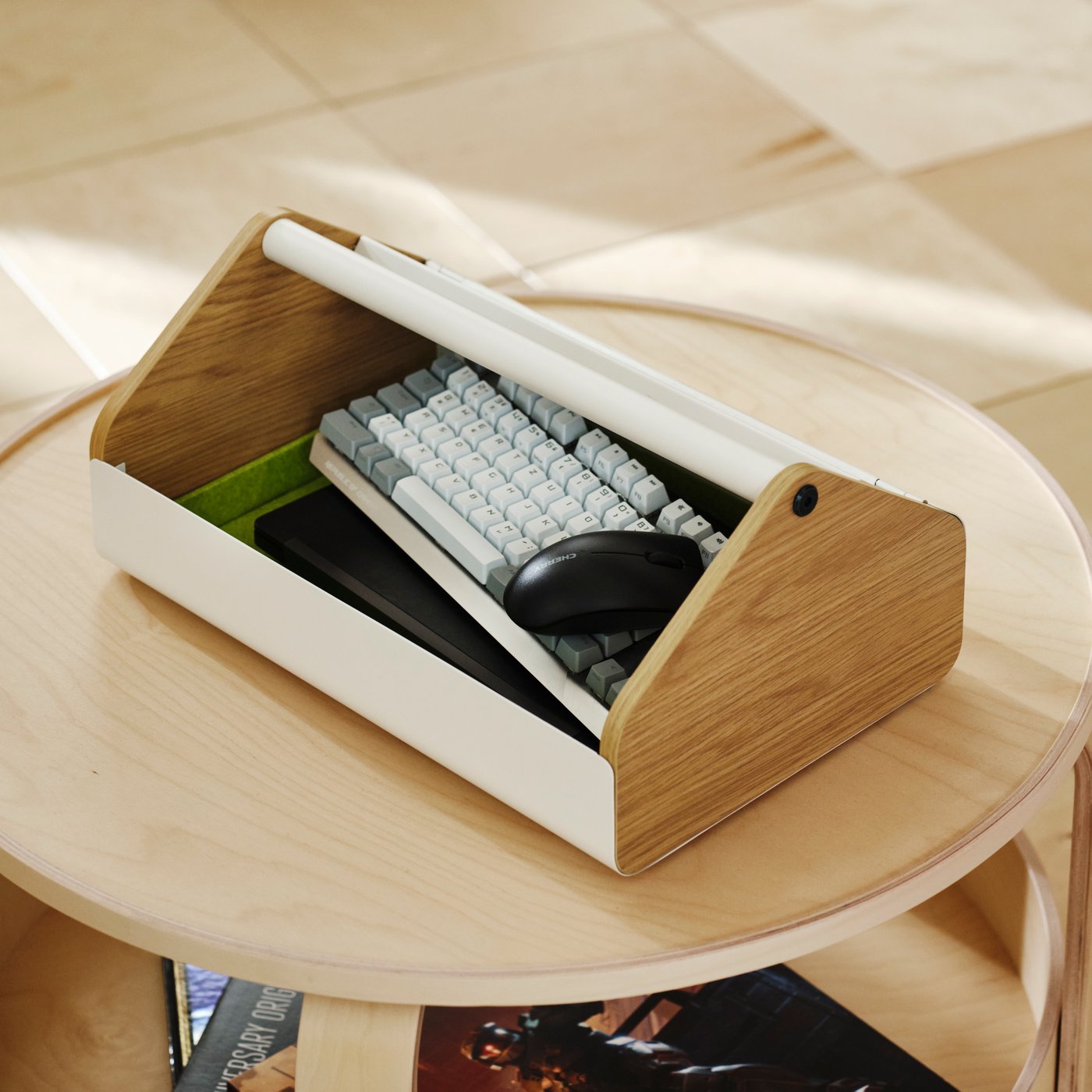 A gaming storage stand supporting a laptop with accessories stored underneath on a dining table.