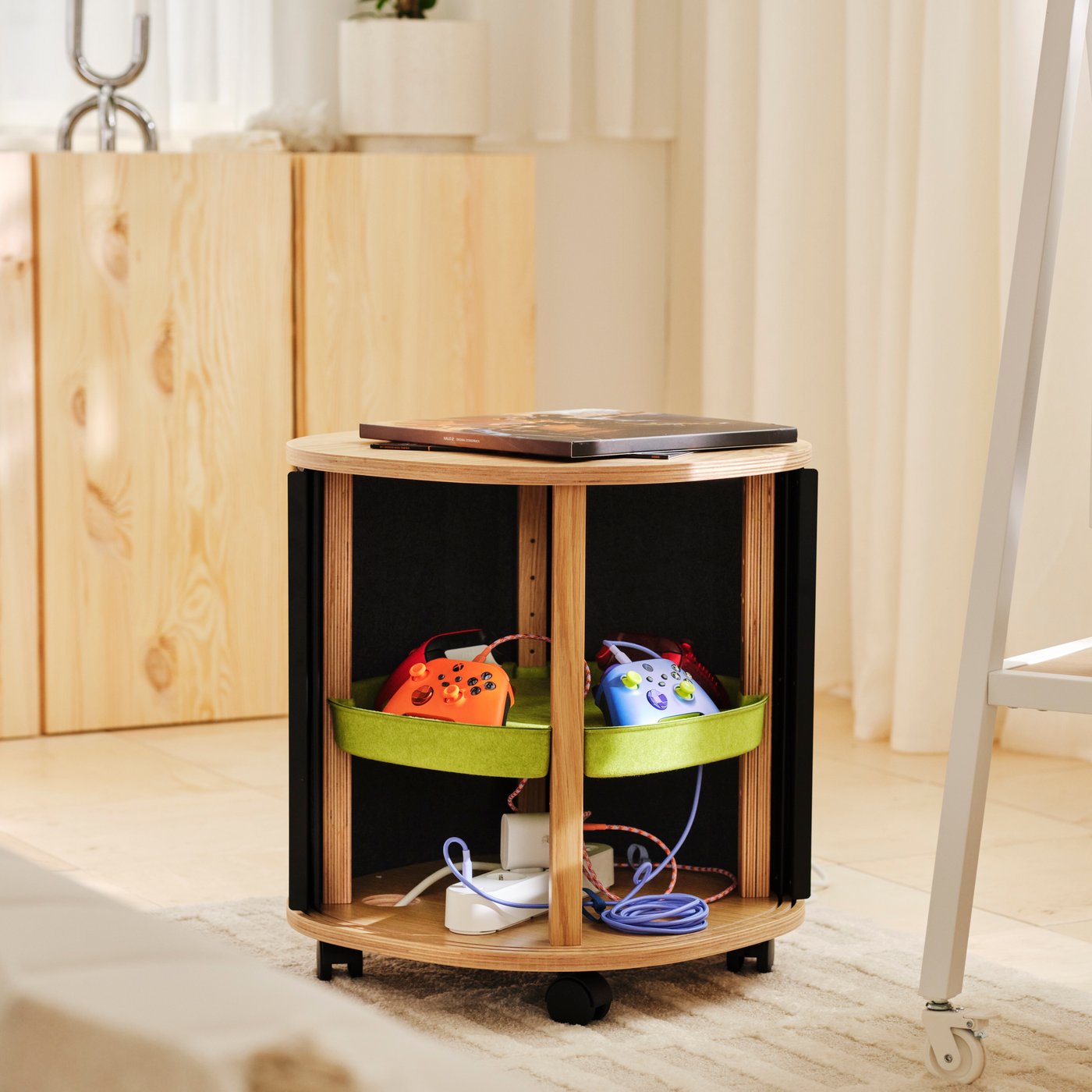A portable storage stand with integrated carry handle holding a keyboard, mouse and accessories on a side table.