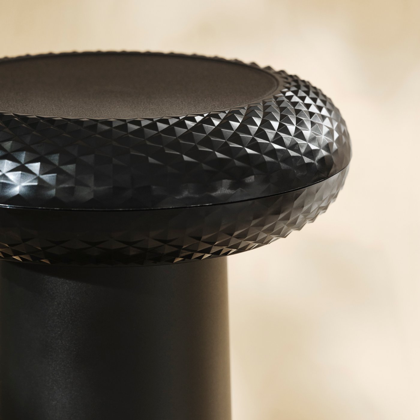 Close-up of the textured seat on a black thumbstick-inspired stool.