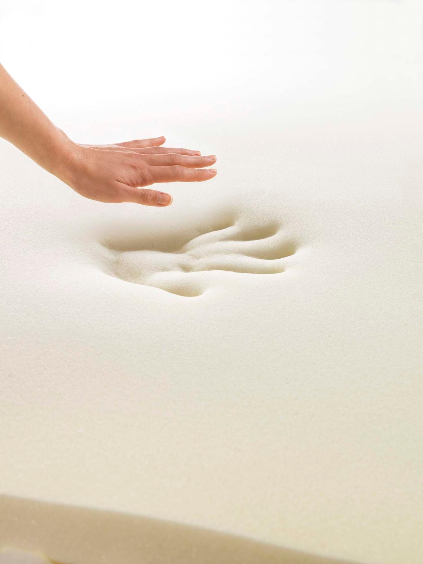 A hand above a piece of foam with an indent of the hand.