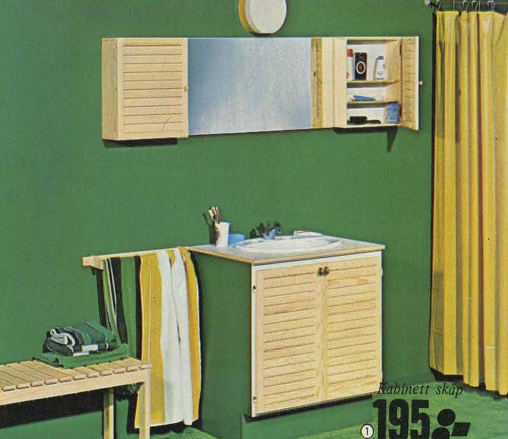 A green bathroom with pine bathroom furniture and yellow curtains.