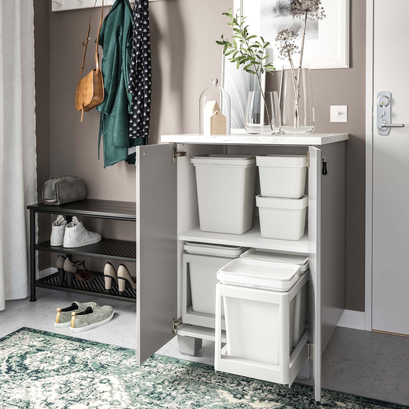 The HÅLLBAR recycling system and containers are revealed in an open cupboard in the hallway.