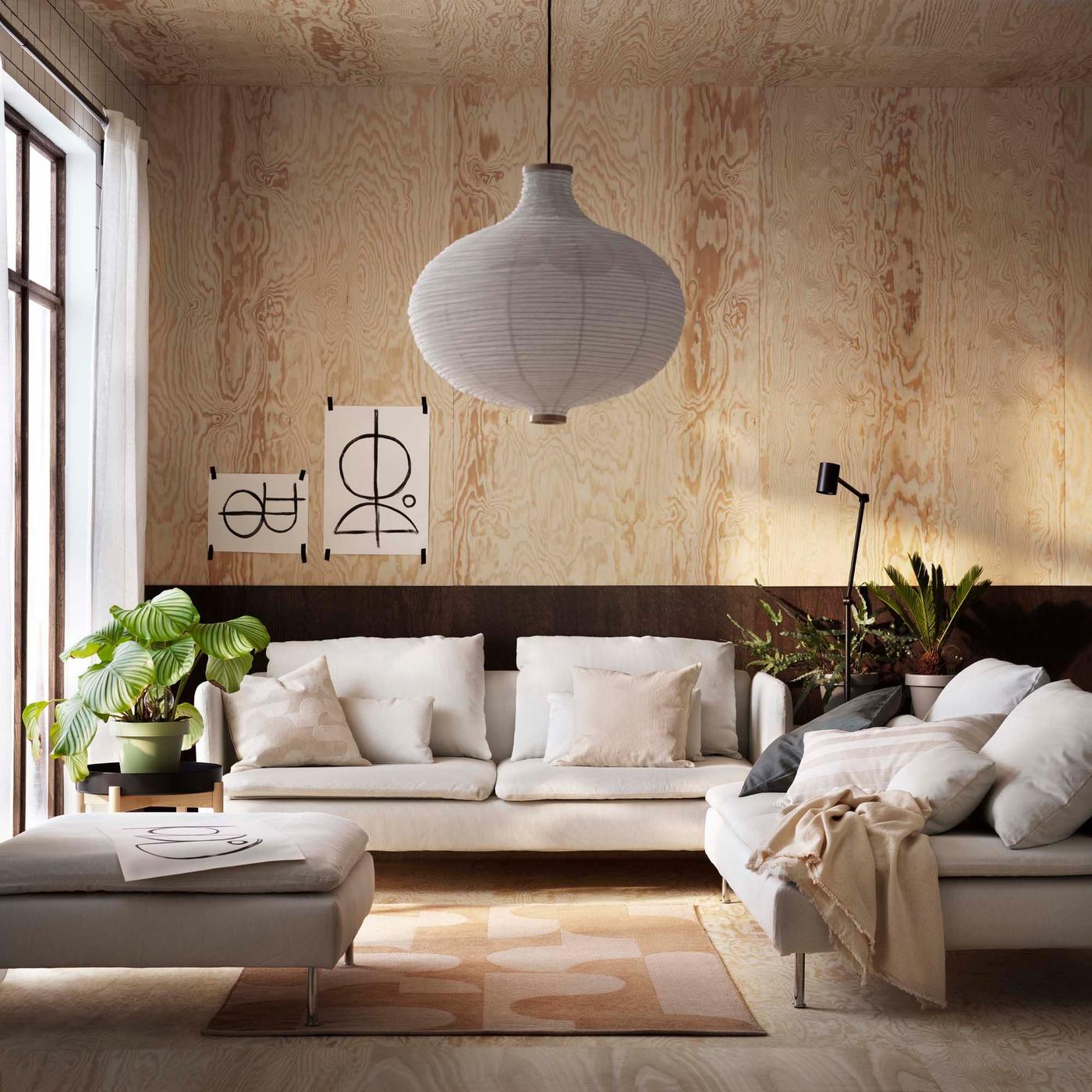 The SÖDERHAMN sofa series in a modern living room with black and wood walls.