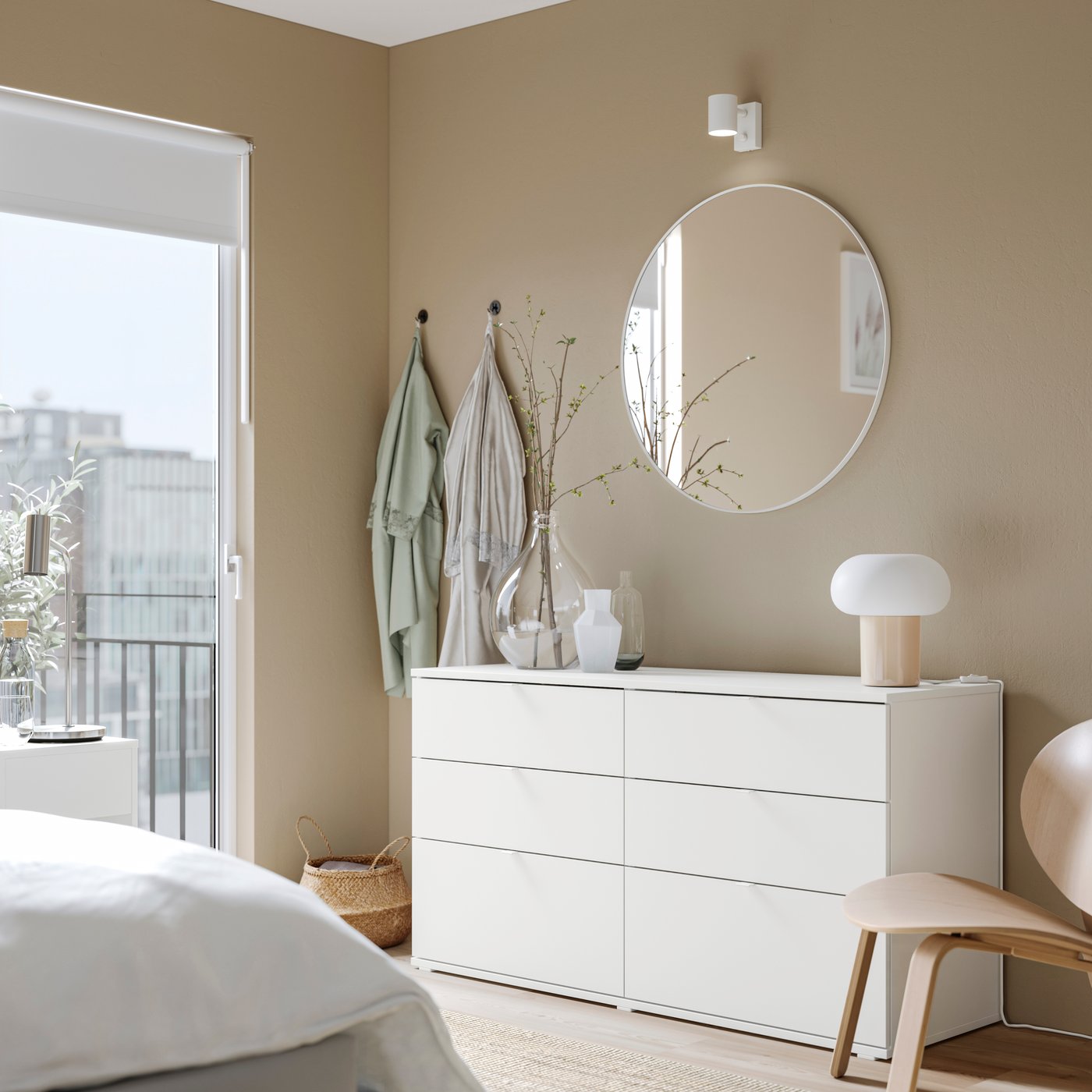 A white VIHALS chest with six drawers in a light coloured, sunny bedroom, next to a large window.