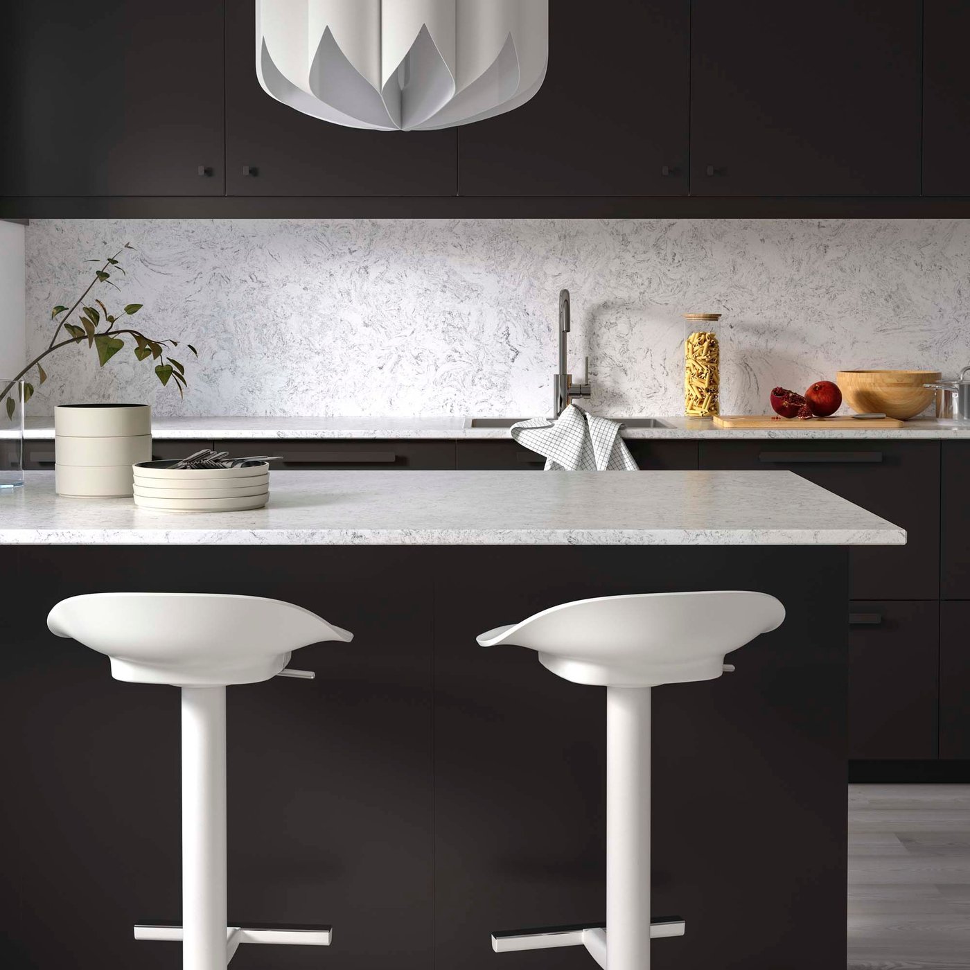 A kitchen with dark cabinets and light LOCKEBO worktops.