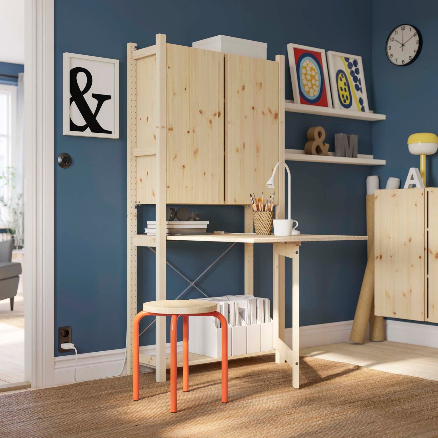 A room with wooden IVAR shelves and a desk.
