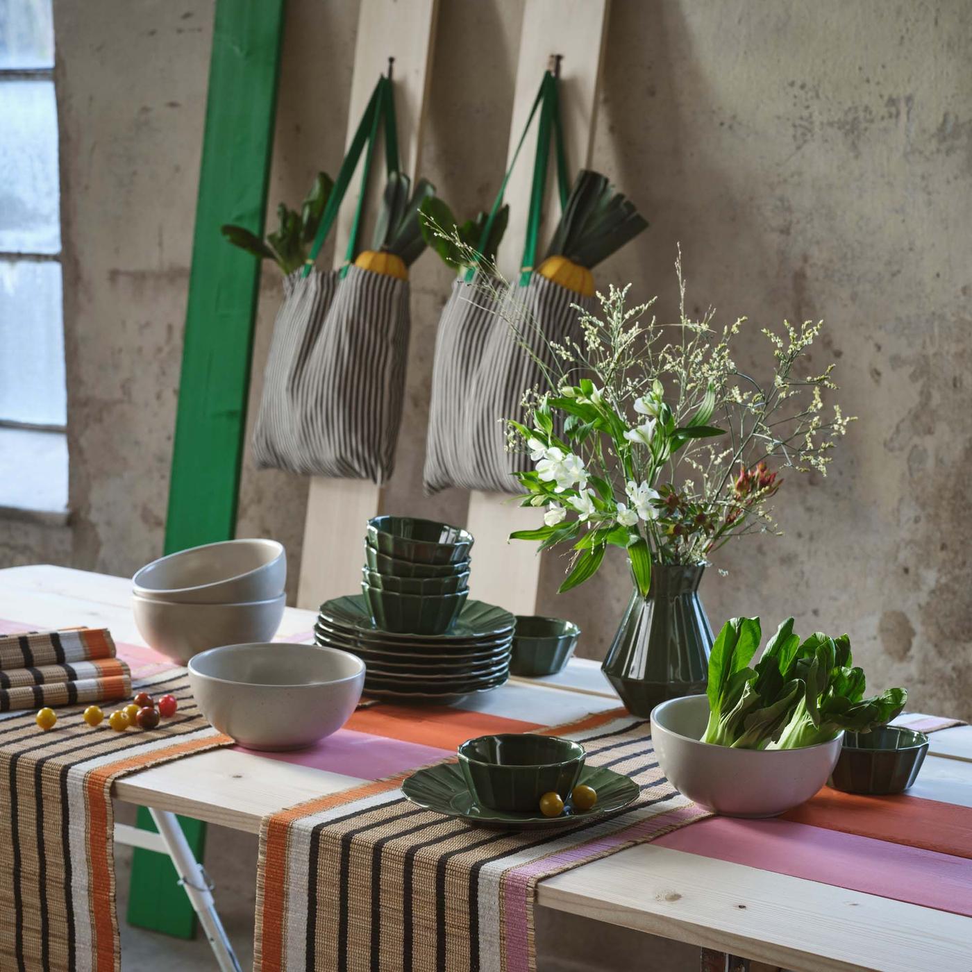 A wooden table decorated with runners, bowls and vases from the MÄVINN collection.