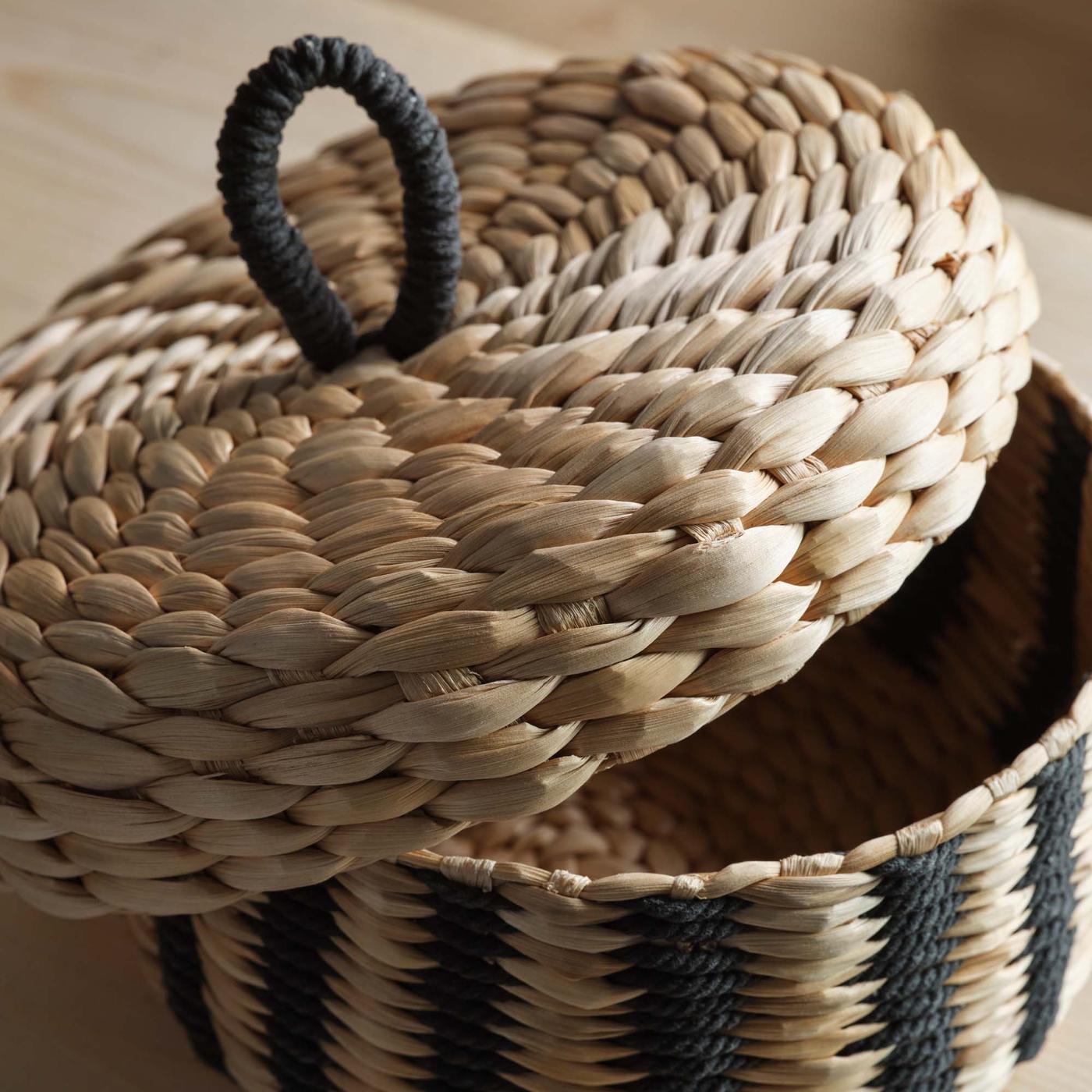 A open black and natural basket with a lid.