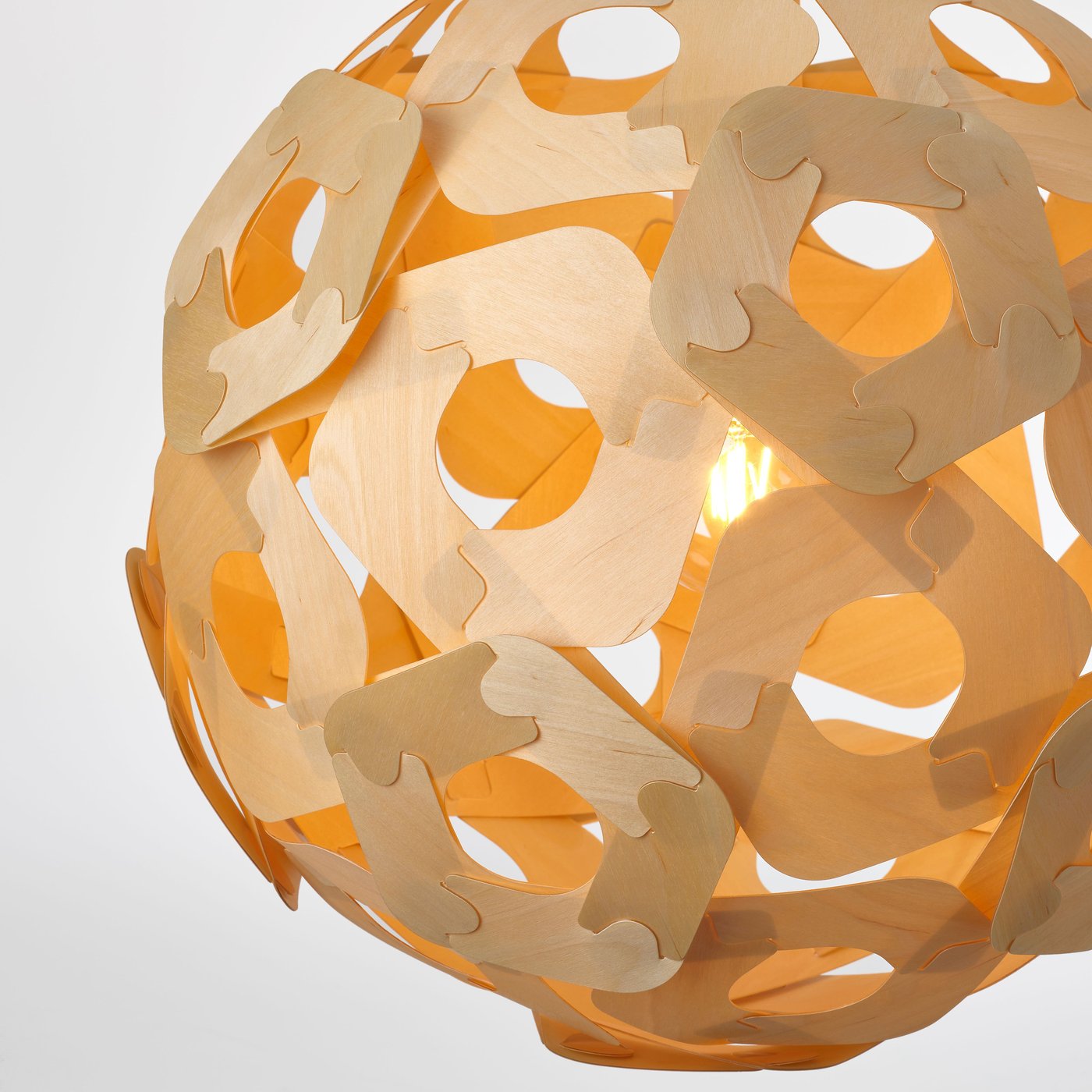 Close-up of a lit wooden-look pendant lamp, glowing warmly and revealing its layered structure and translucent design.