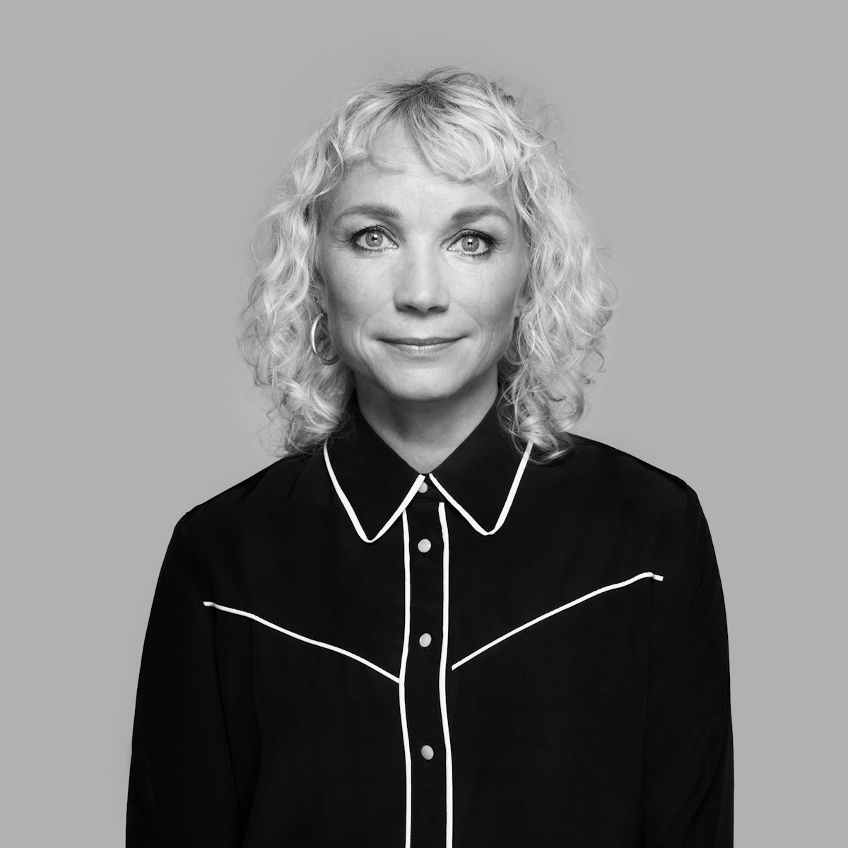 A black and white image of Maria Vinka looking at the camera.