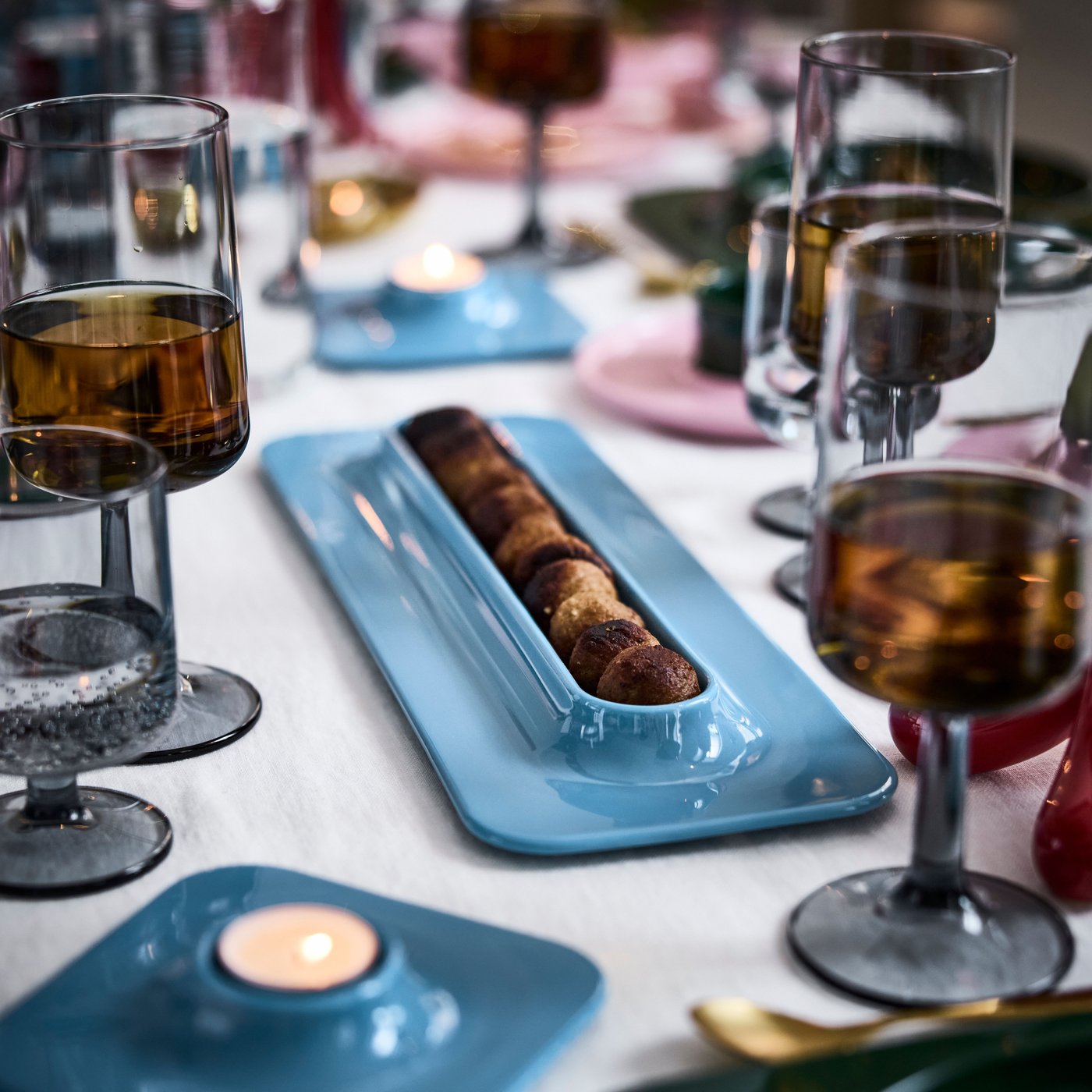 A long blue meatball platter on a festive table.