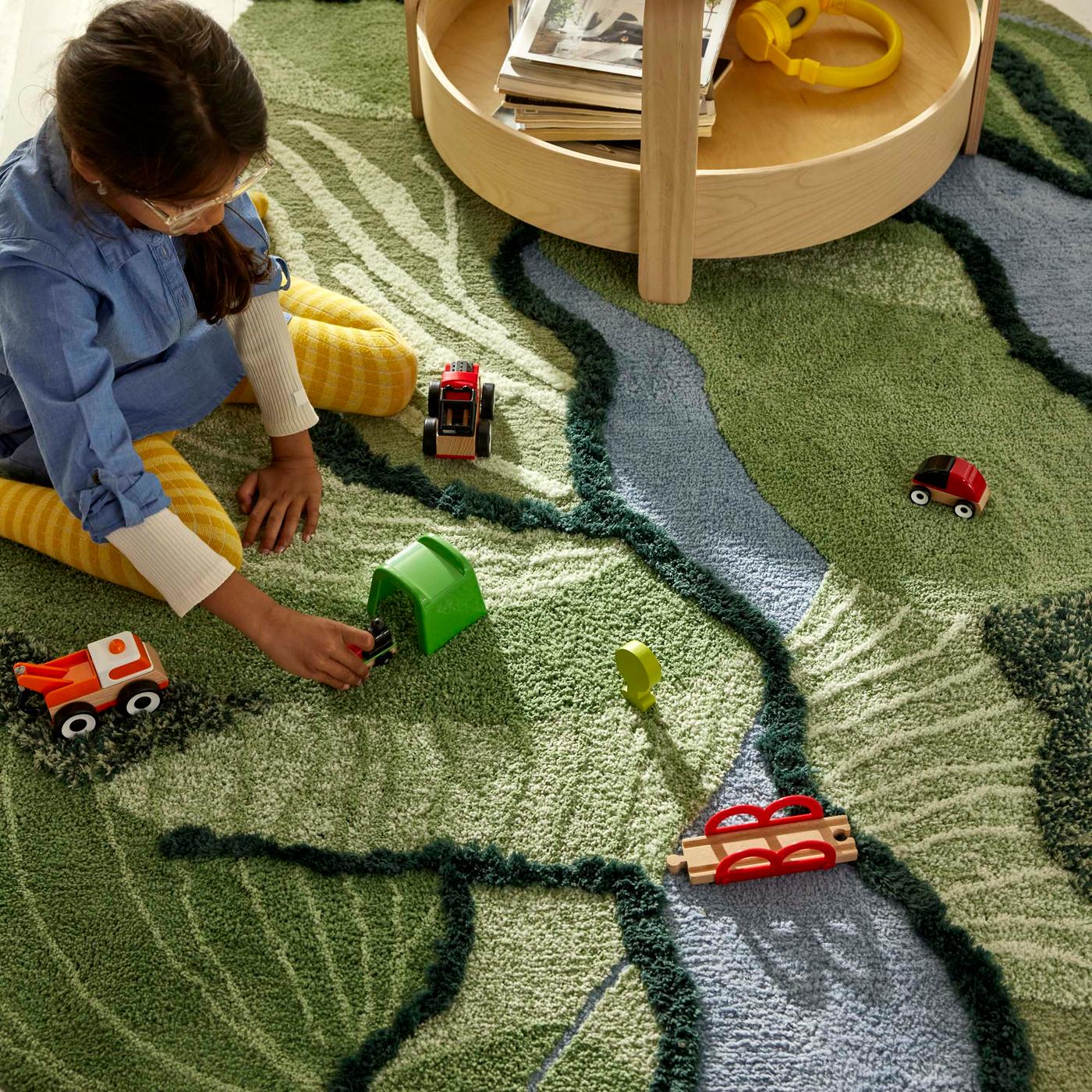 An aerial shot of a child playing on a textured rug.