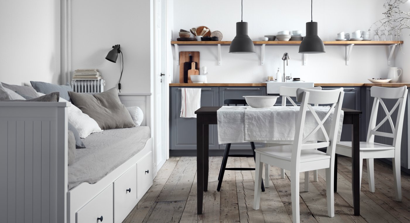 A grey and white kitchen, dining room with grey and white, rustic style furniture.
