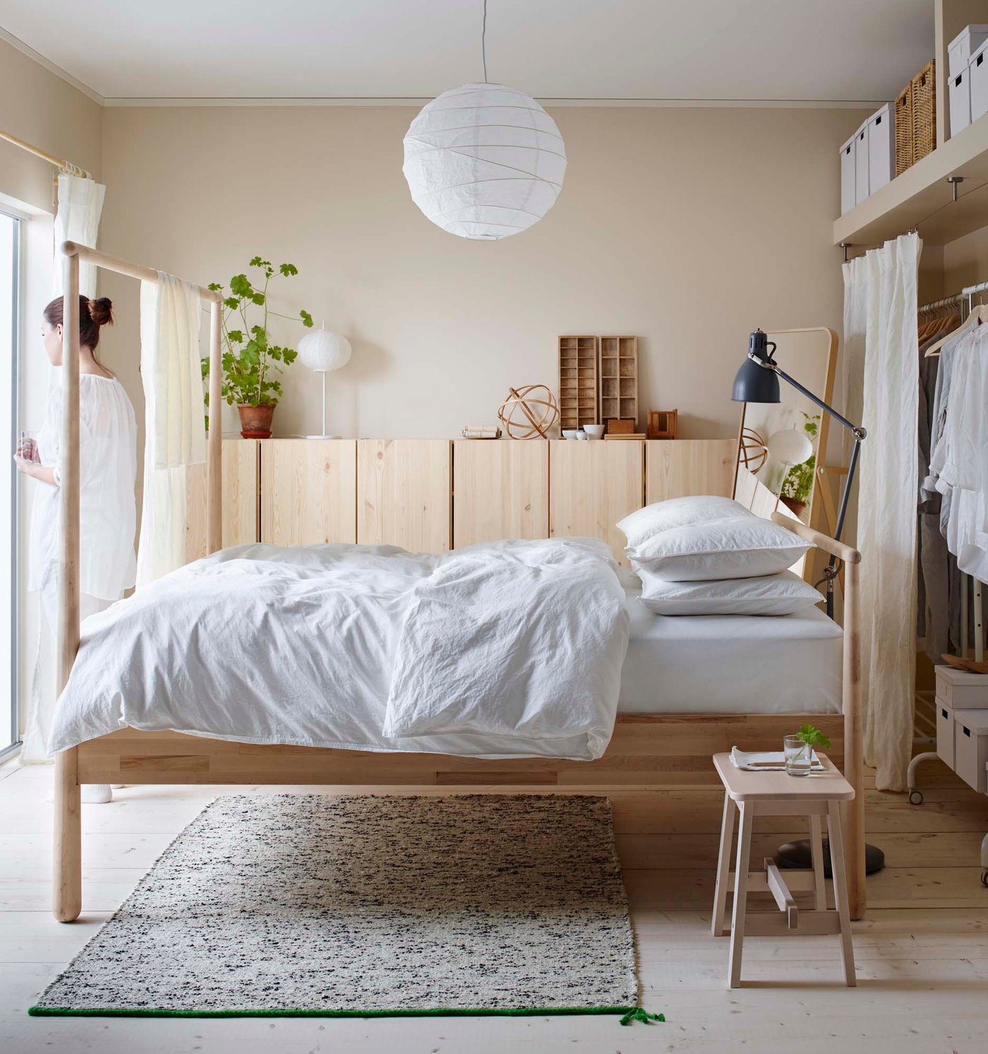 The 2017 IKEA catalogue with a bed with light blue bedlinen in the foreground and wood cupboards behind.