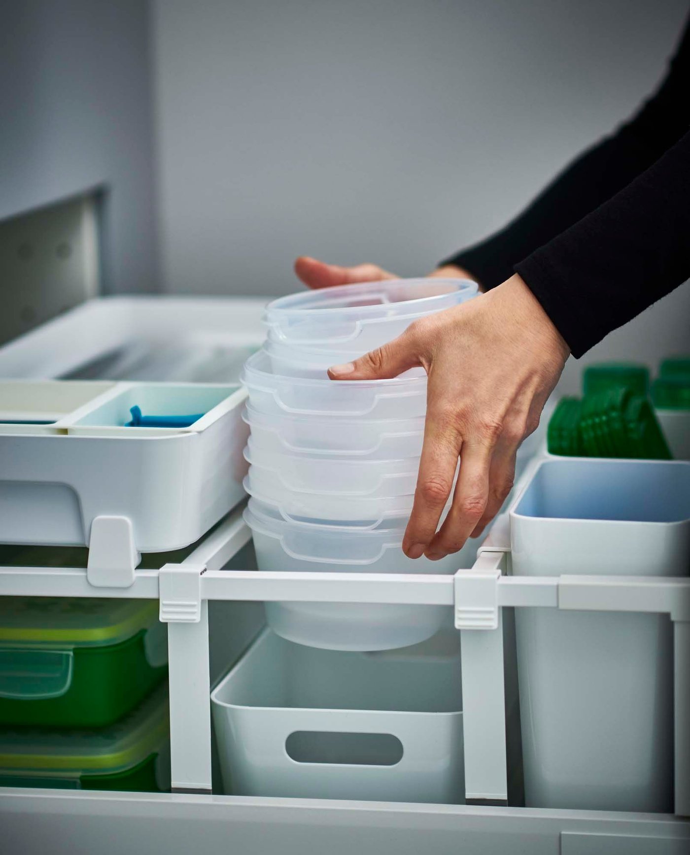 A drawer filled with different types of storage containers.