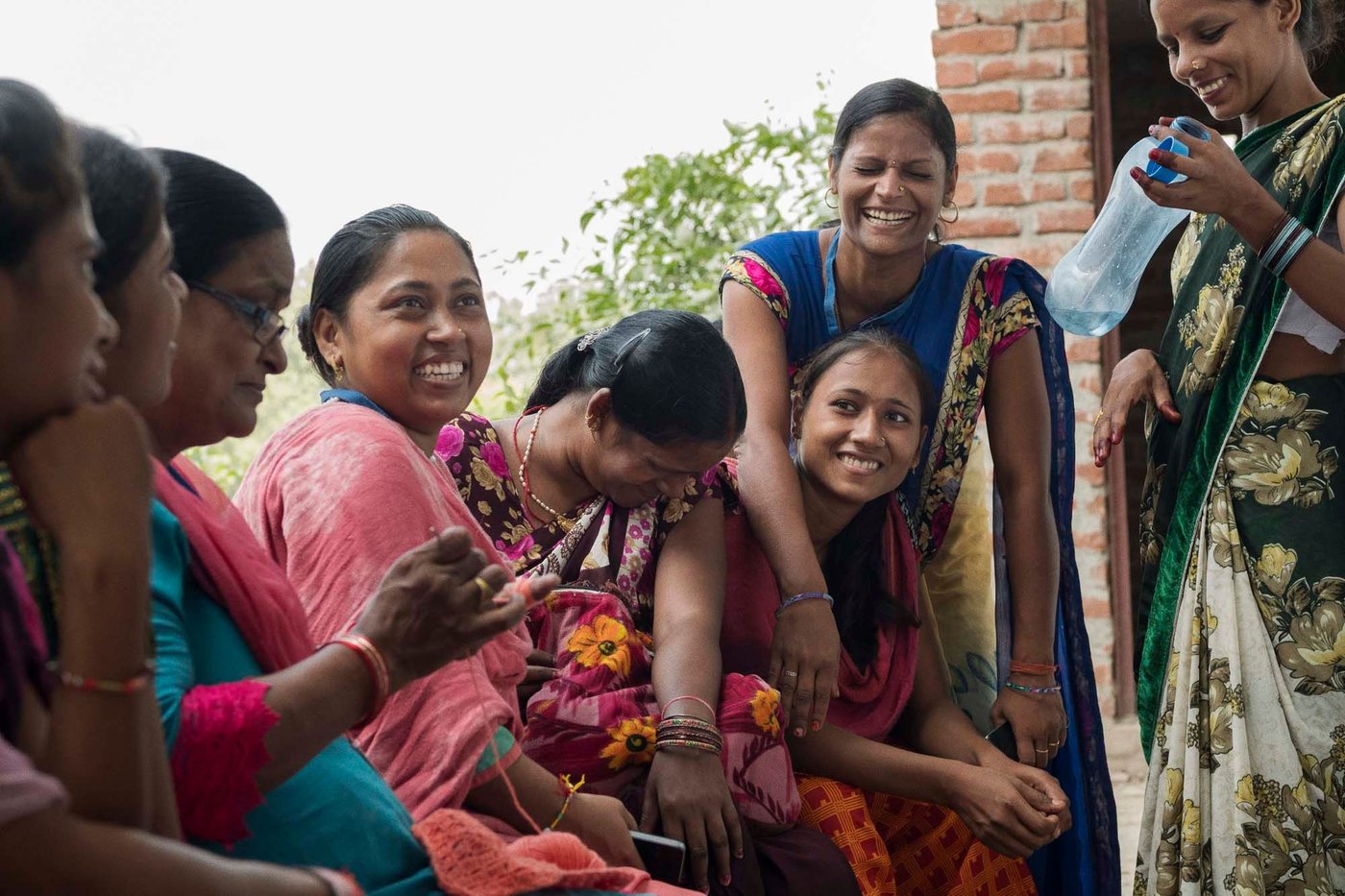 A group of women sit together. They are smiling and laughing.