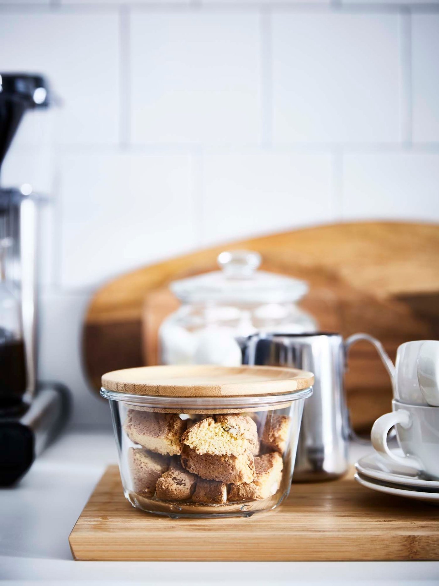 Biscotti stored in a glass container with a bamboo lid.