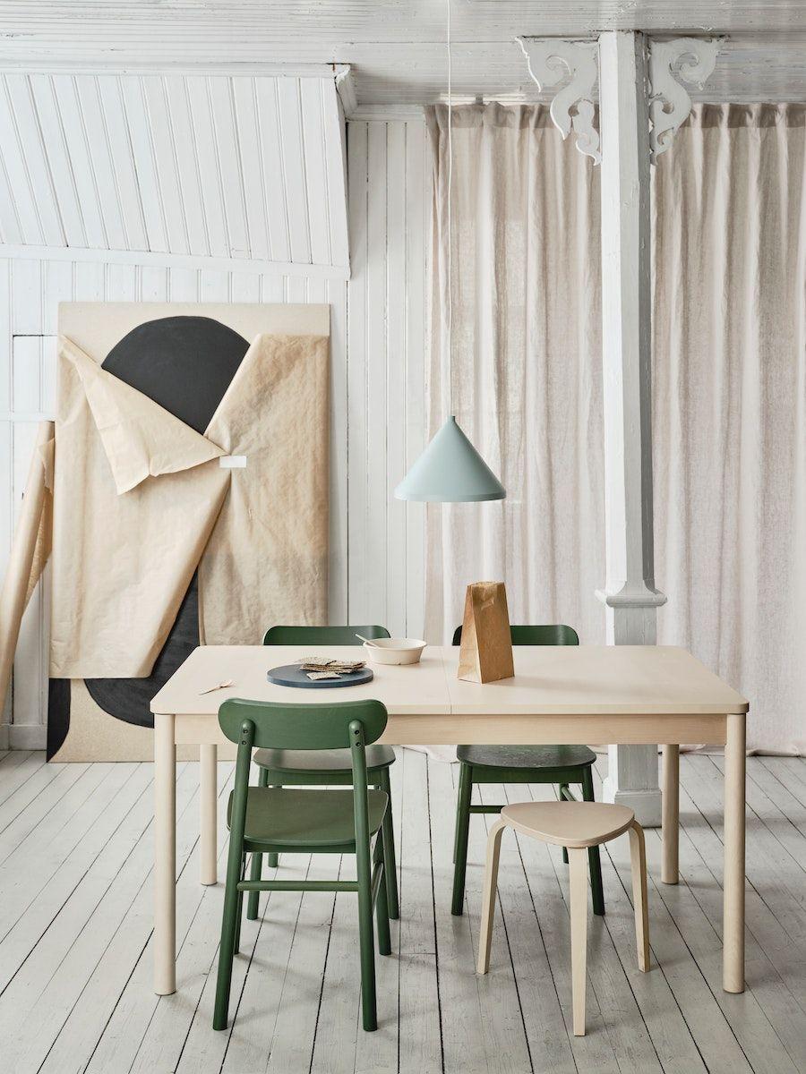 A room with white, wood-panelled floors and walls, with a RÖNNINGE dining table in birch and RÖNNINGE chairs in green.