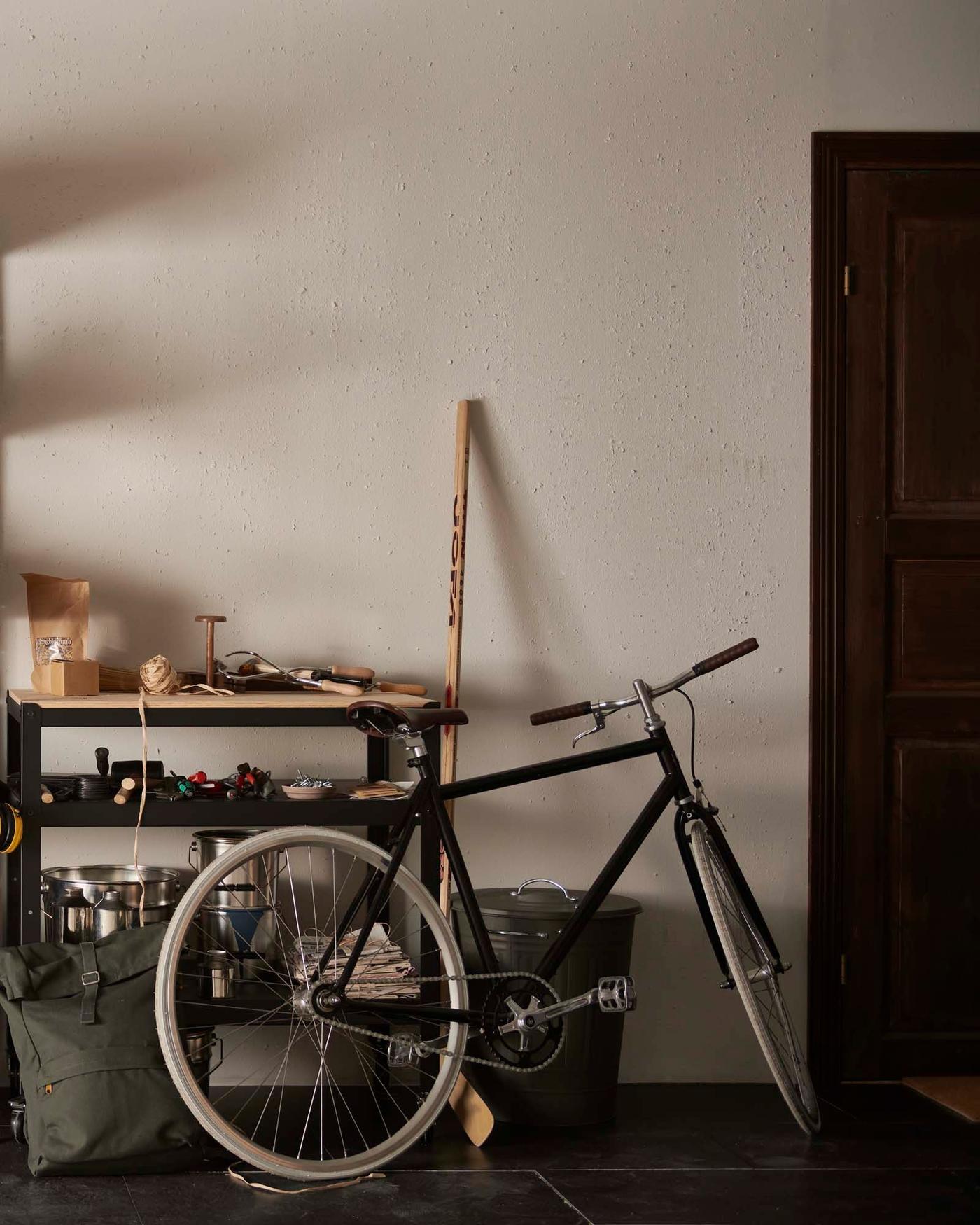 A bicycle parked in a home garage/work area.