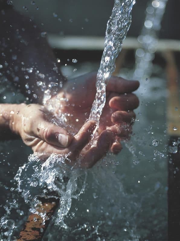 Hands catching pouring water.