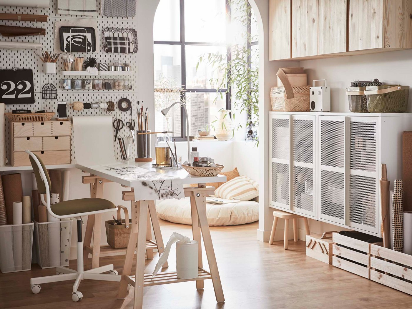 A bright, creative, artistic workspace with a large arched window.