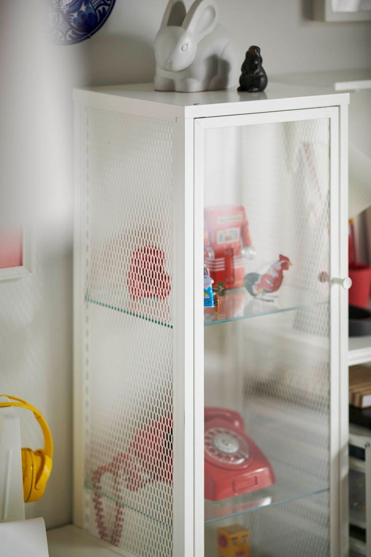 Toys and ornaments displayed inside a BAGGEBO cabinet with glass doors.