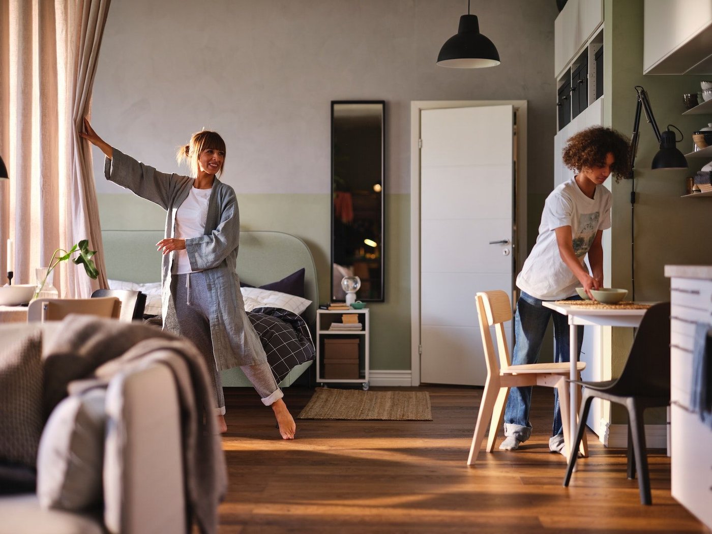 Two people in a studio apartment setting.