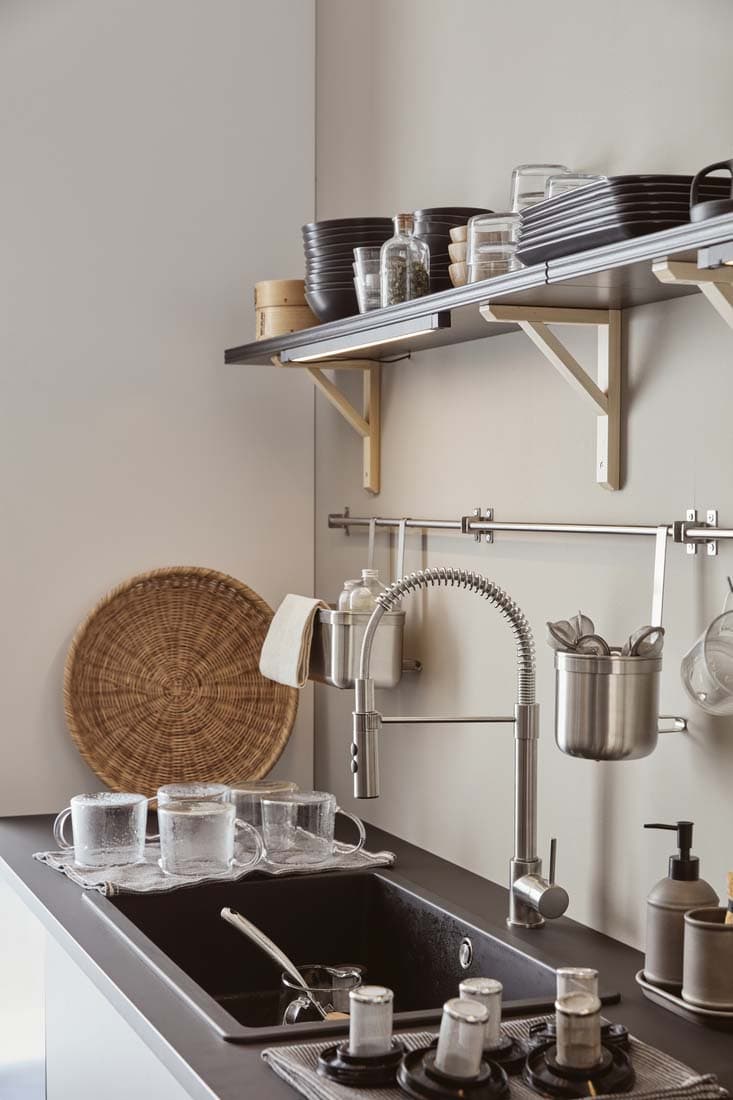 The sink area of a black, grey and white kitchen.