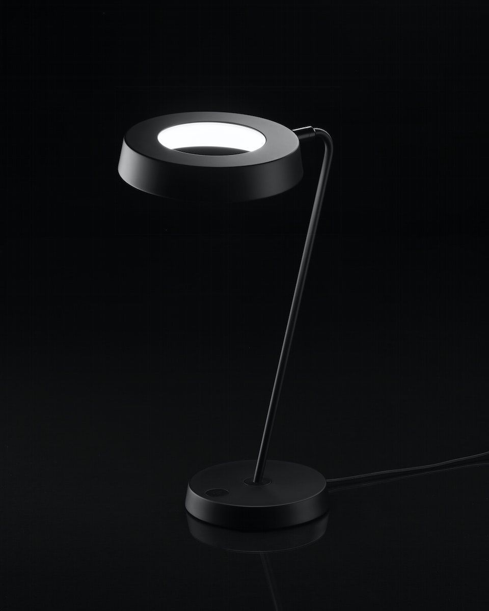 Illuminated OBEGRÄNSAD LED work lamp on a black background.