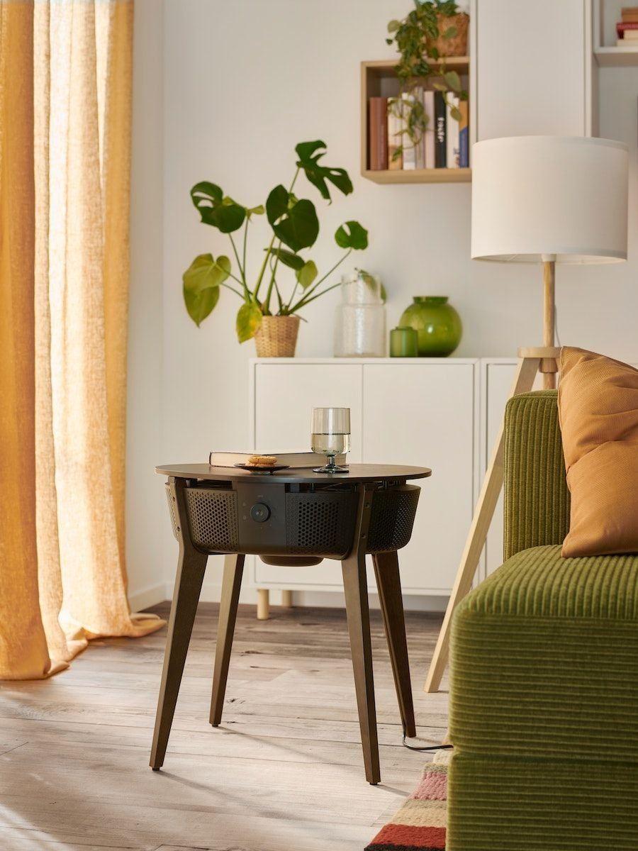 A STARKVIND table with air purifier in stained oak veneer/dark brown in a bright living room with green sofa.