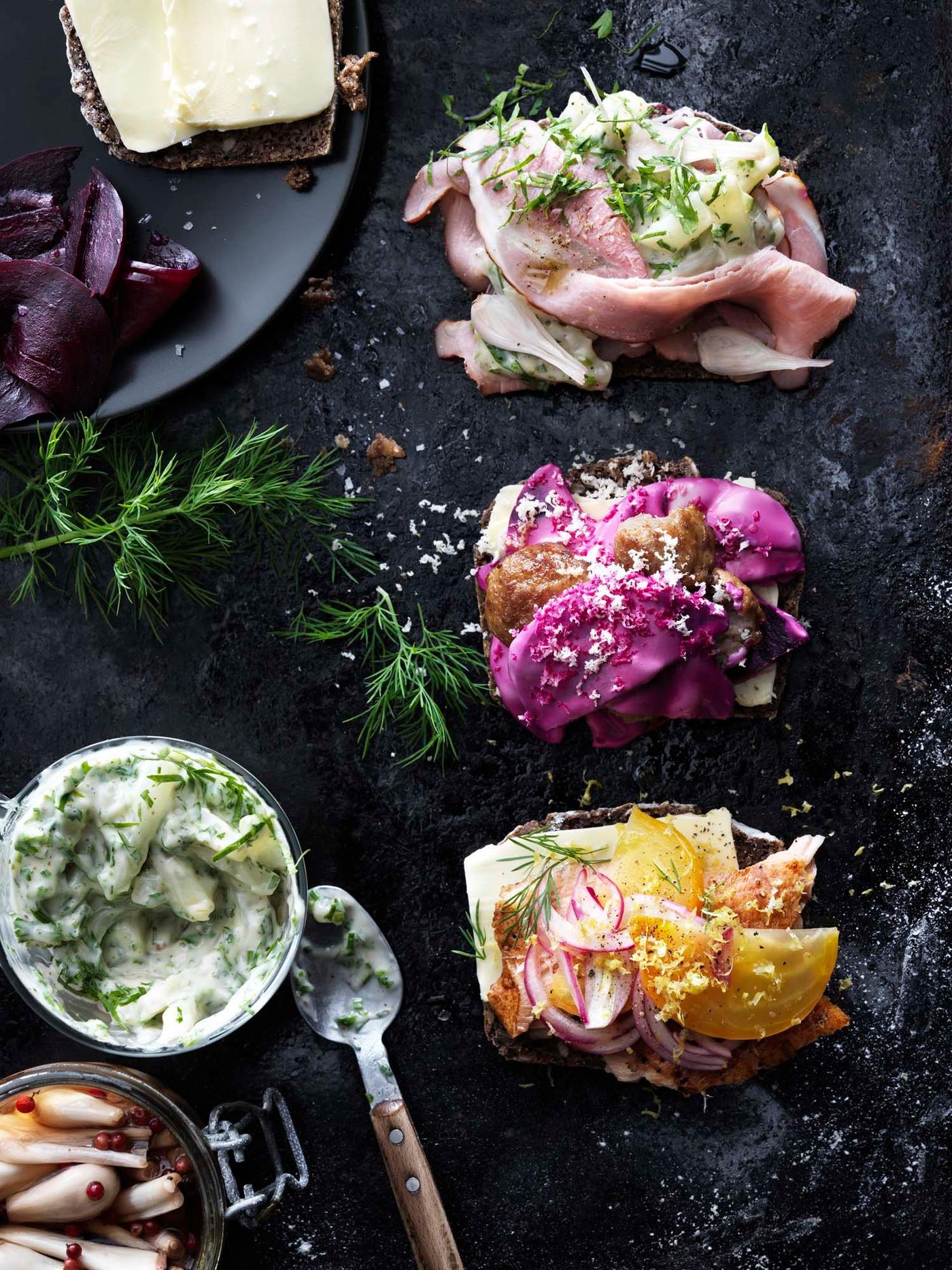 A variety of open-faced sandwiches on a black surface.