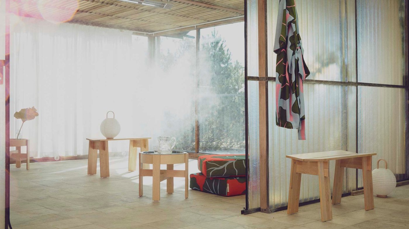 A sauna area with benches and tables from the BASTUA collection