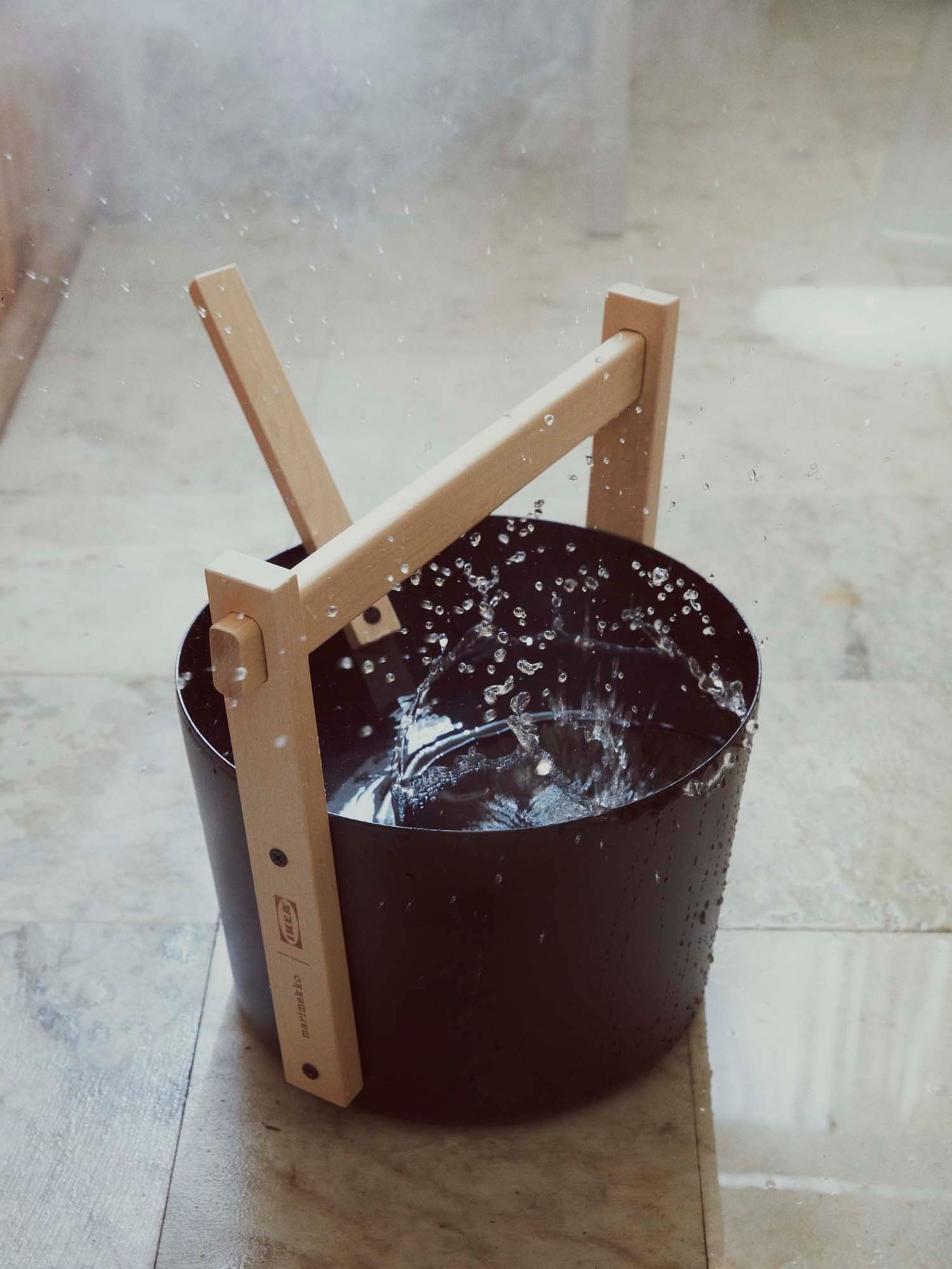 A sauna bucket with a wooden handle.