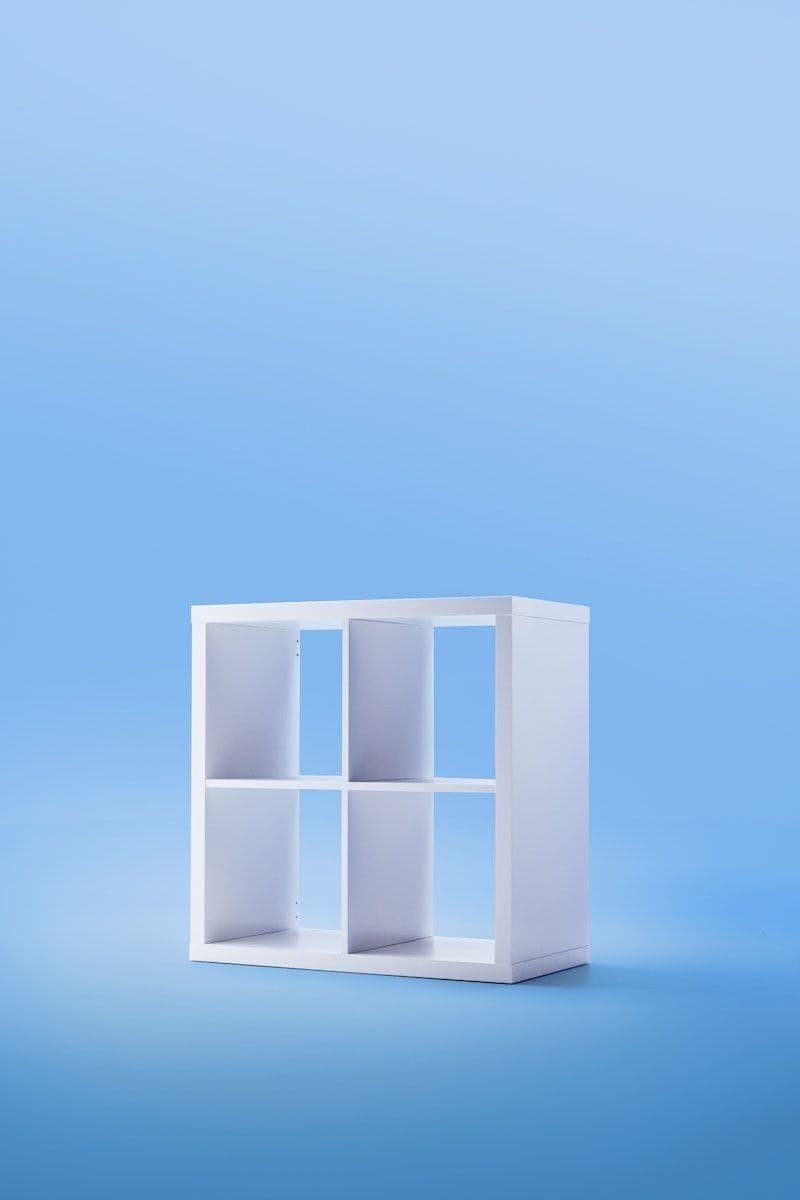 A white KALLAX shelf unit on a light blue infinity background.
